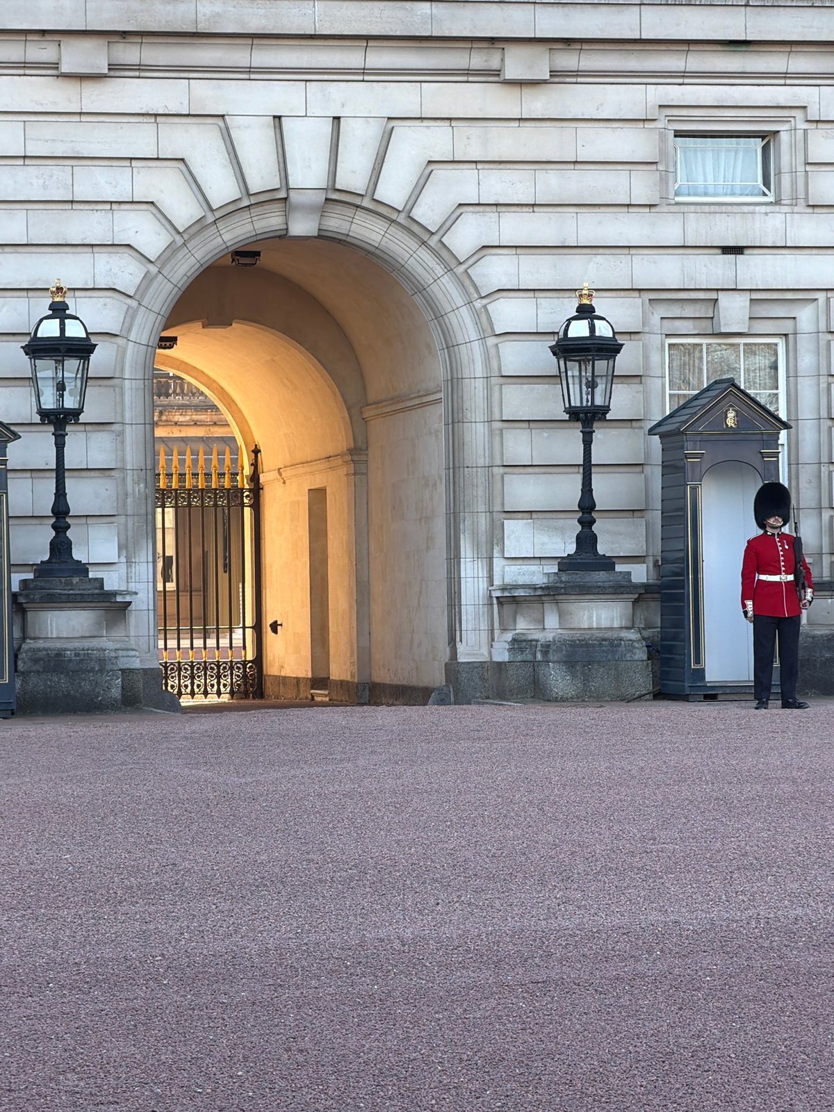 Traditional British guard stands watch at London stone archway