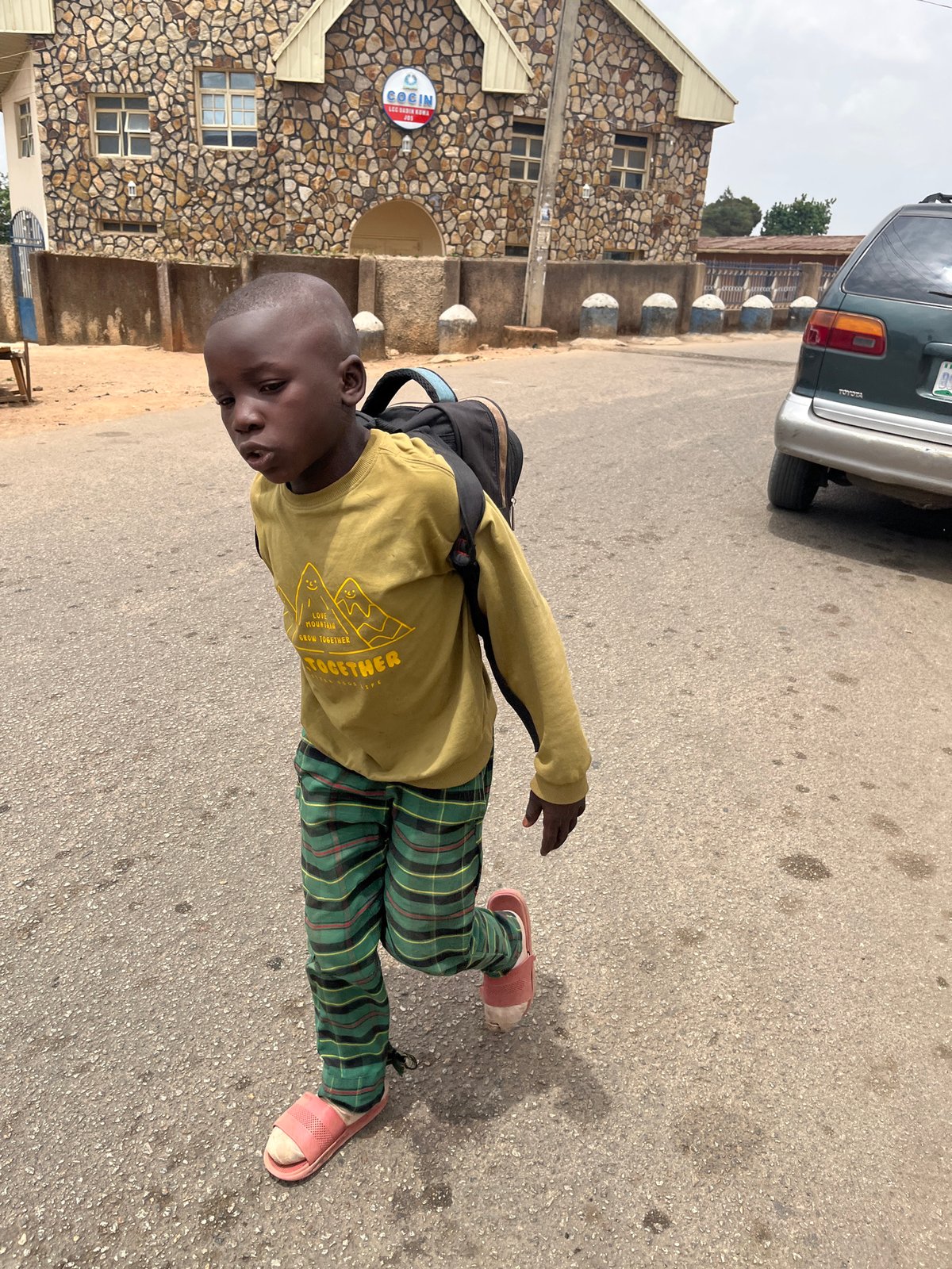 Young boy with backpack observed on street in Jos