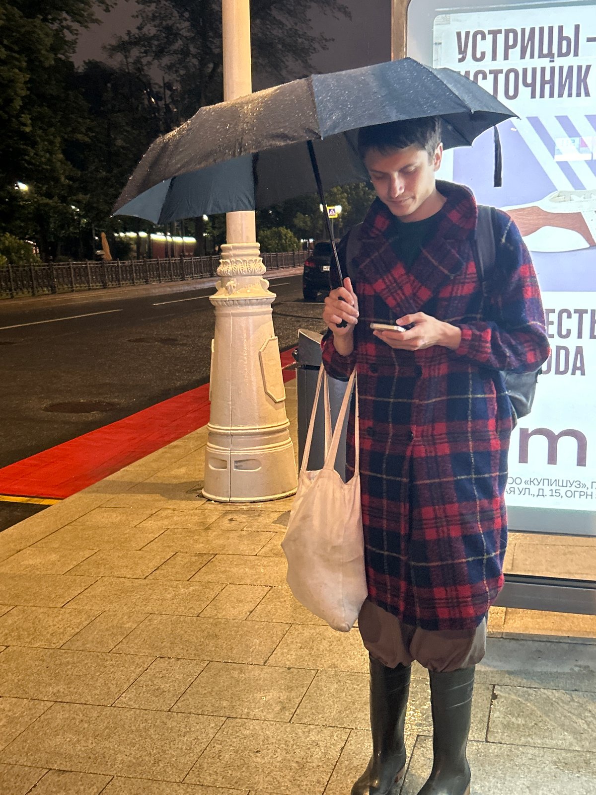 Rainy night commute — bus stops, wet streets, tired passengers