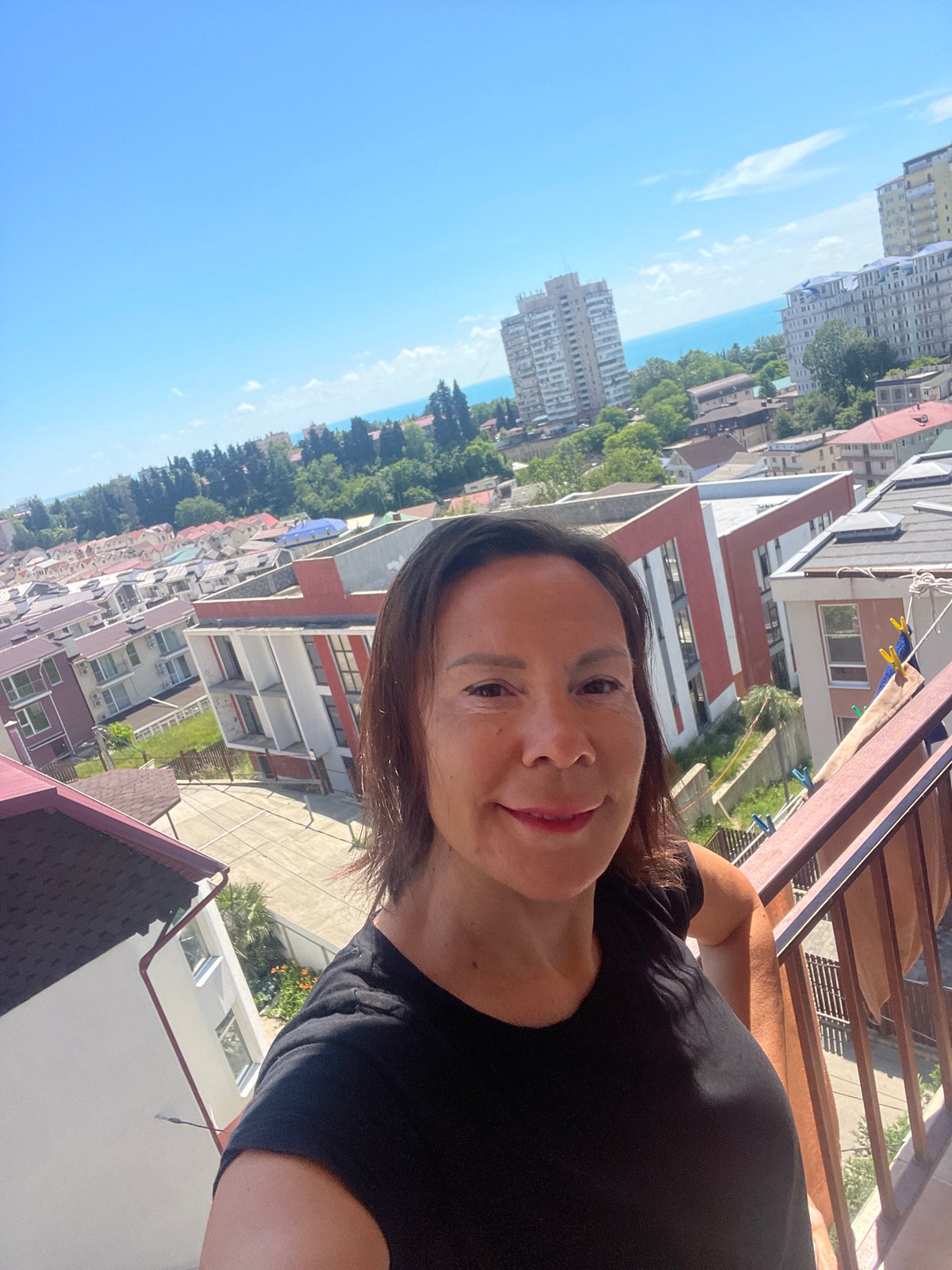 Woman selfies, airplane spotted over sunny Sochi cityscape