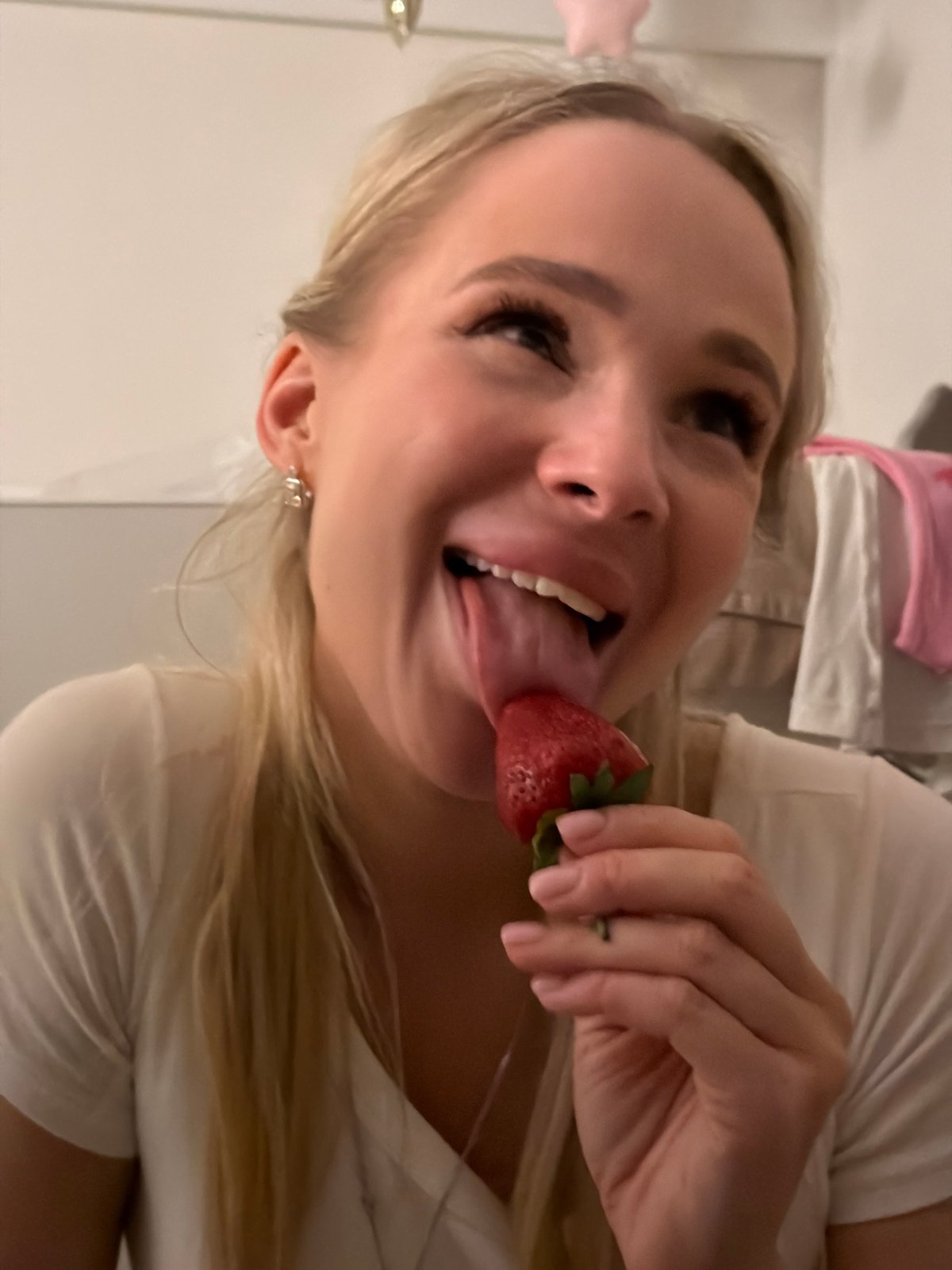 Two women share strawberries in bedroom gathering, Odintsovo