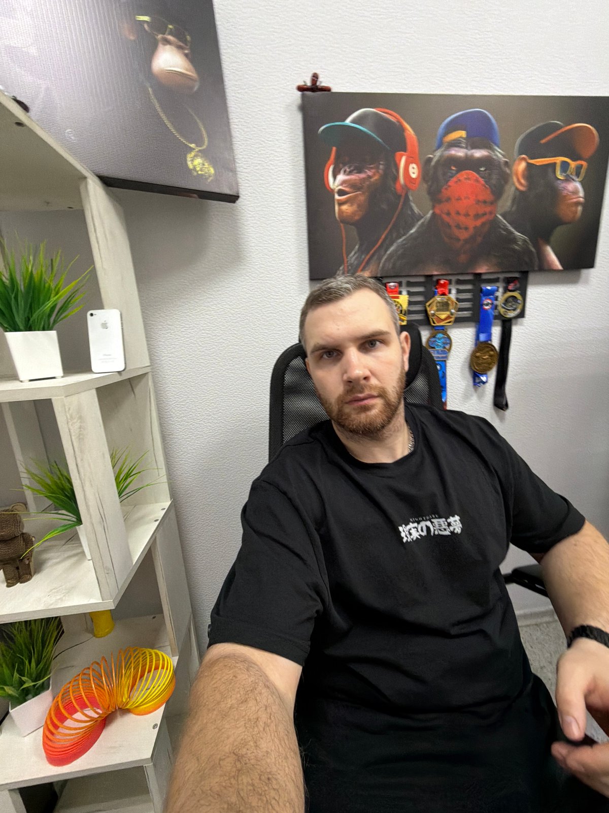 Man documents metallic spinning top in home office setting