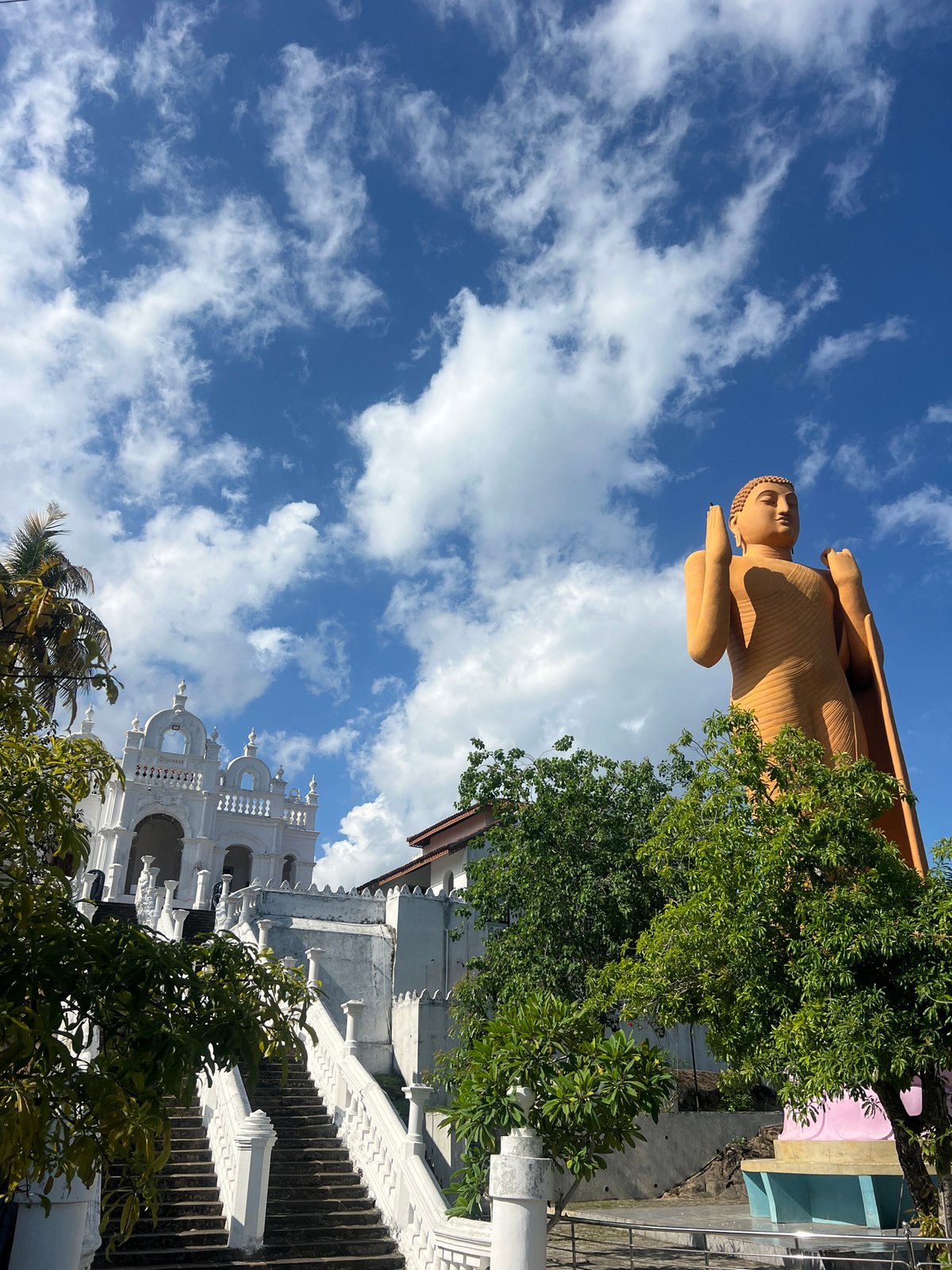 Visitors document Buddha statue at Hikkaduwa temple complex