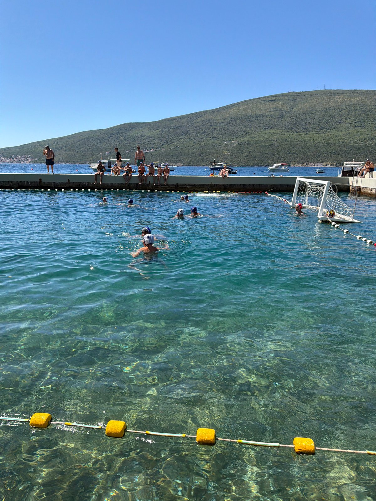 Water polo match in a scenic Montenegrin coastal bay