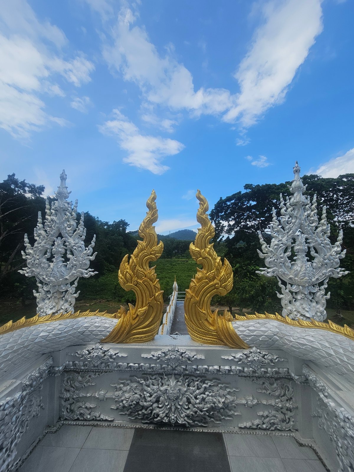 Inside and around a white Buddhist temple in Thep Krasatti