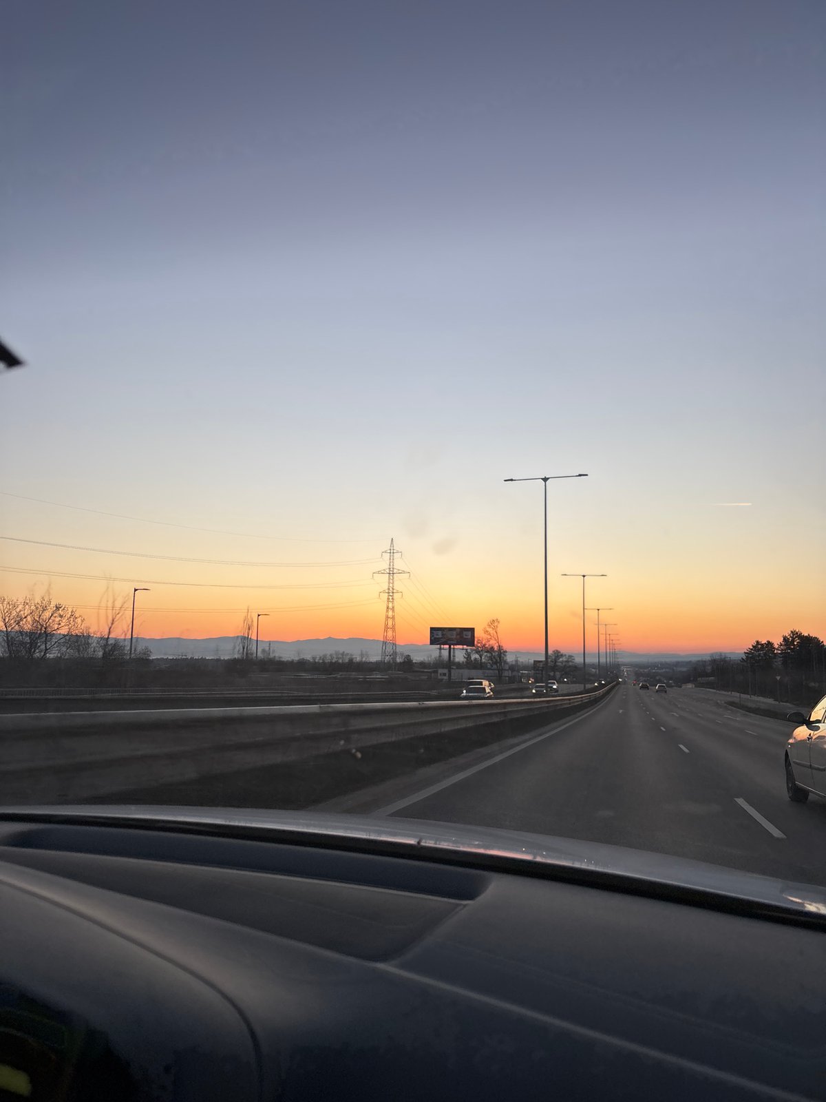 Highway traffic observed near Sofia with directional signage at dusk