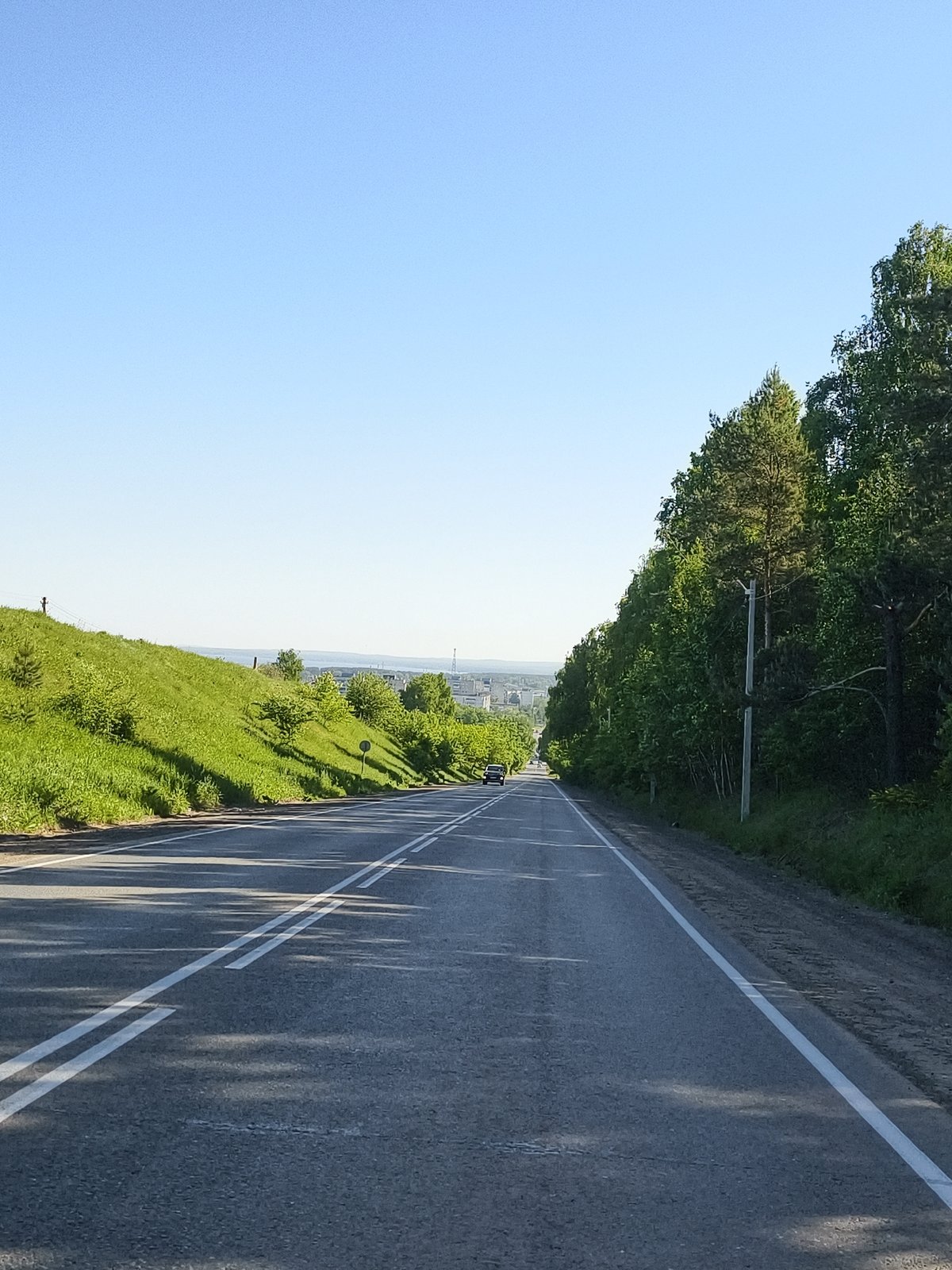 Morning road view captured approaching Chaikovsky cityscape