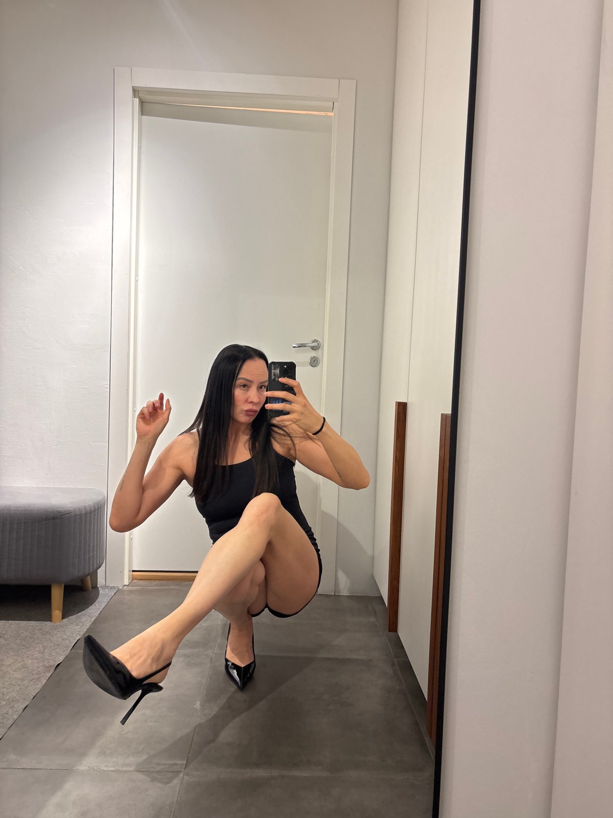 Woman takes fitting room selfie in black dress, Chaikovsky
