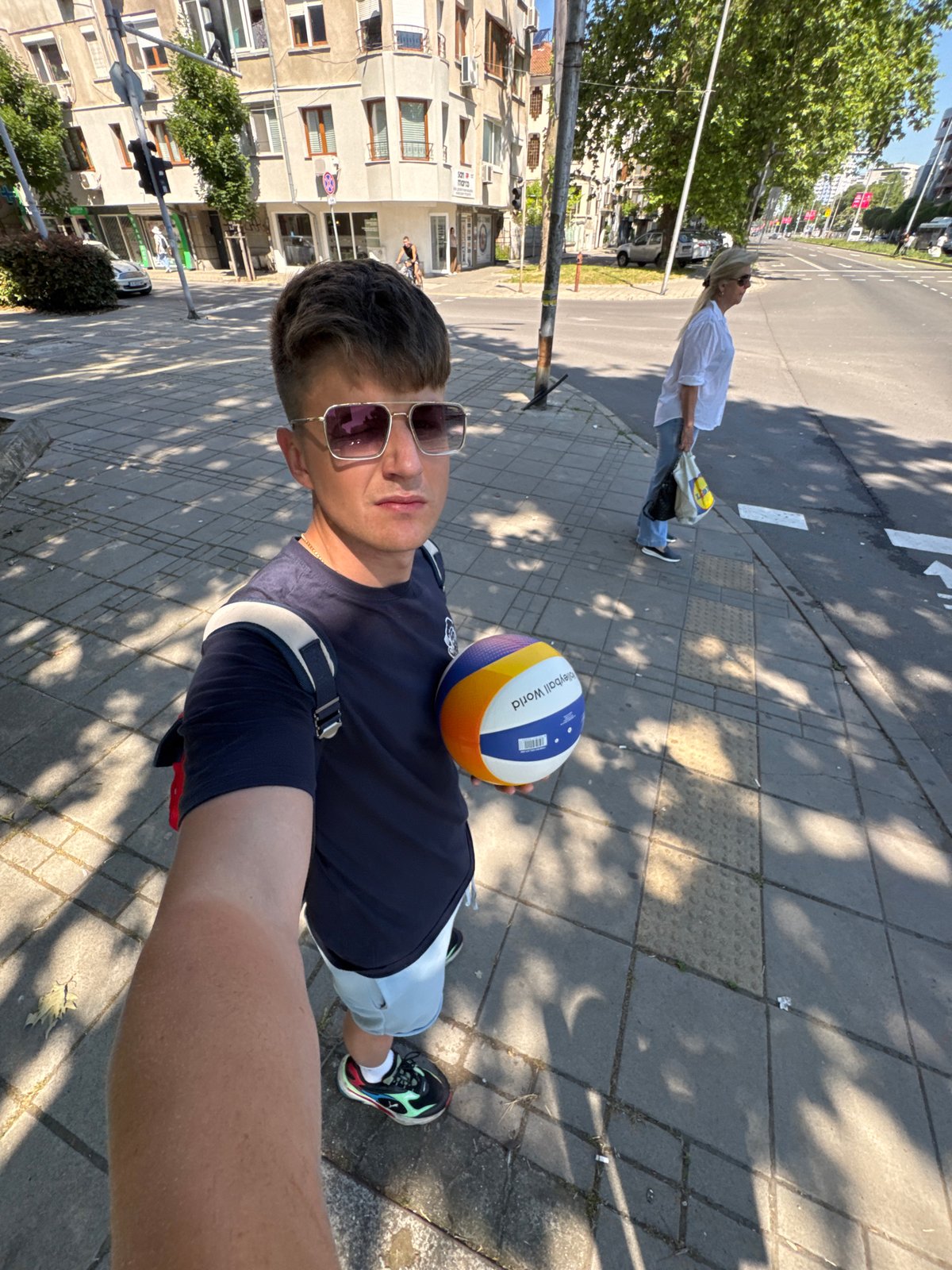 Man takes volleyball selfie on sunny Burgas sidewalk
