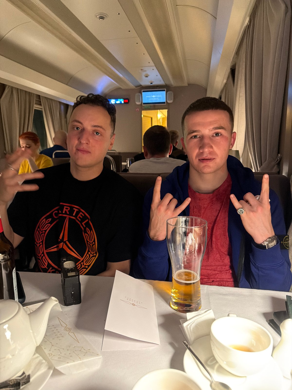 Two men seated inside private aircraft cabin over Moscow