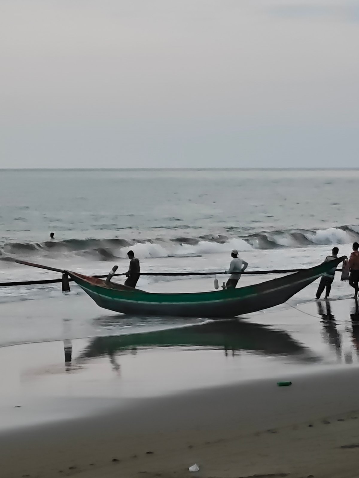 Net hauling and fishing boats on an Indonesian beach at dusk