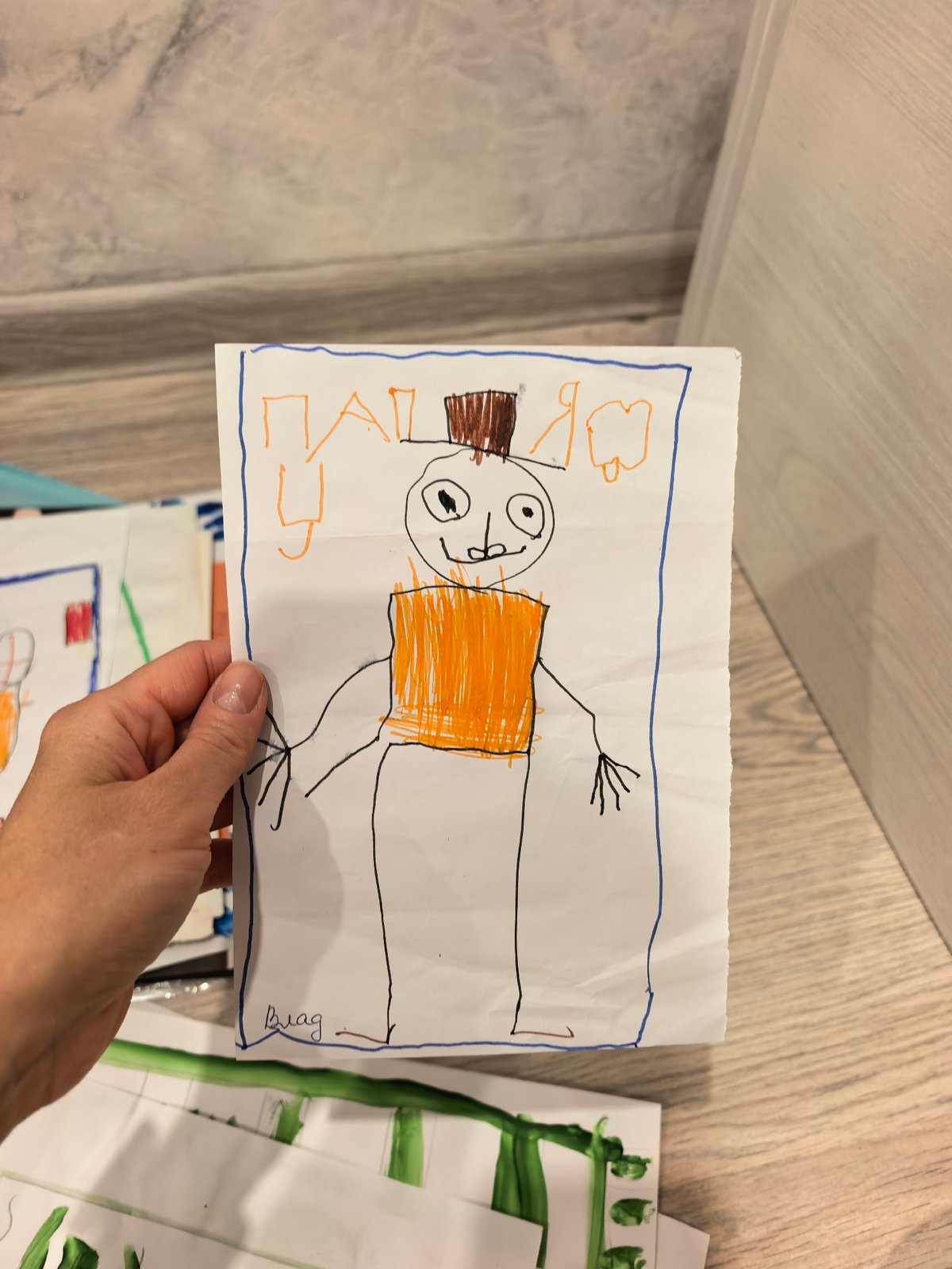 Parent documents children's artwork and playtime in Sterlitamak home