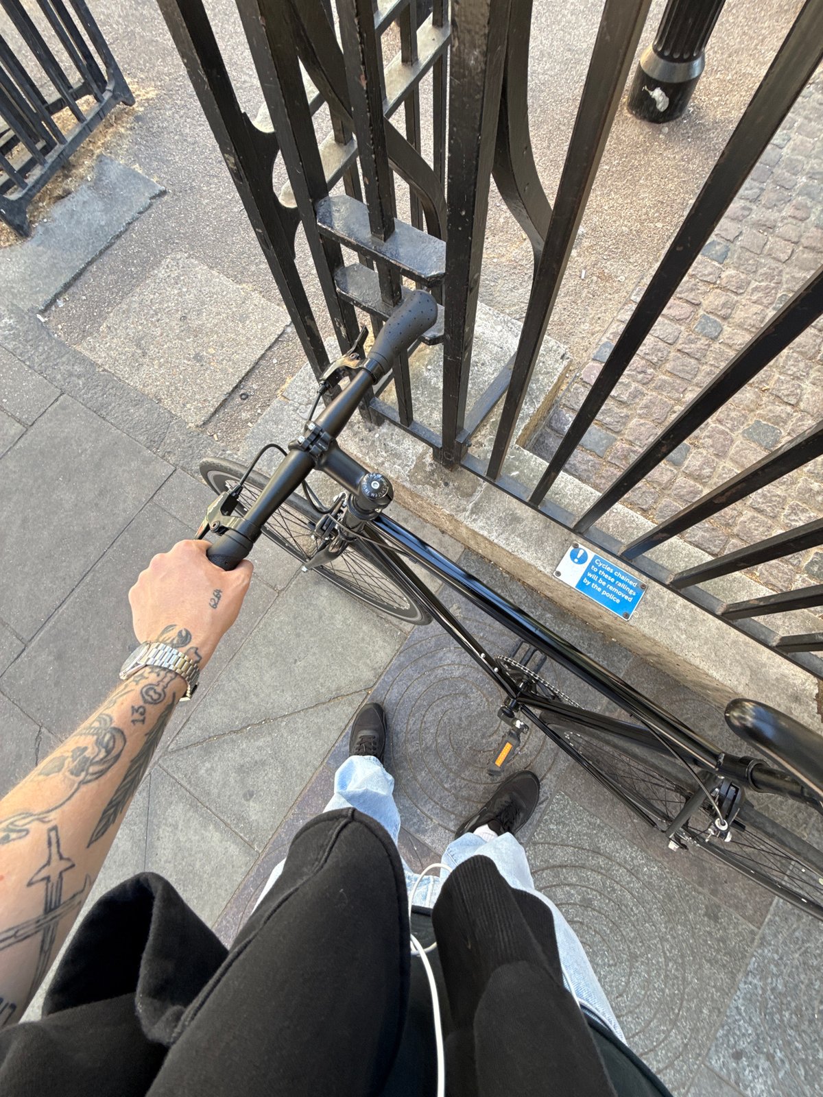 Cyclist pauses with bicycle on London street