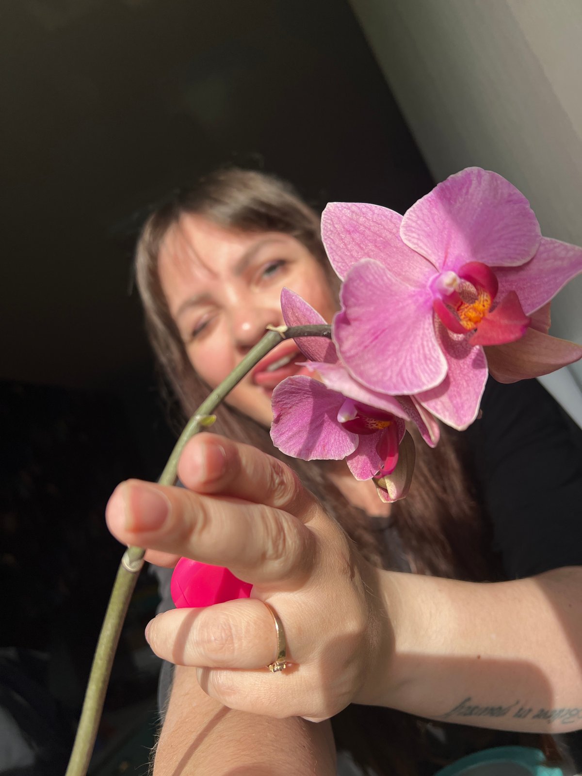 Woman photographs herself with orchids in Noviy, Russia
