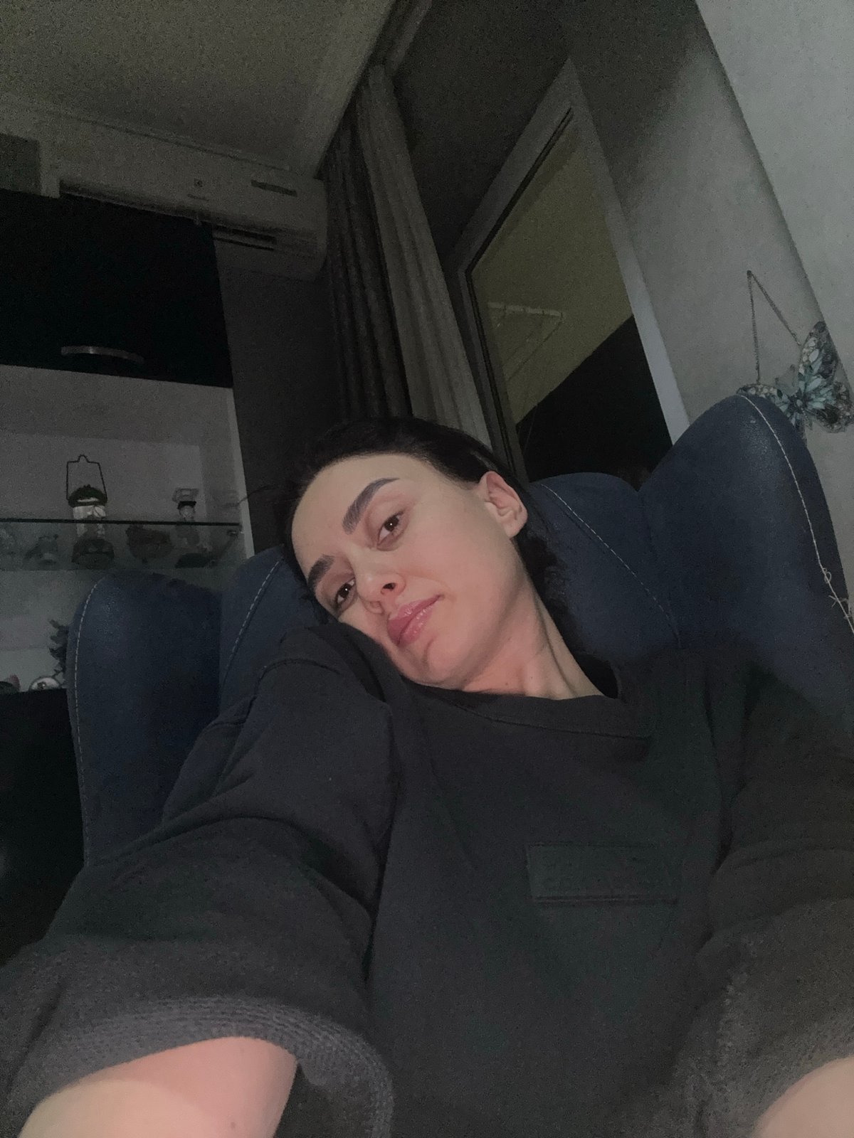 Woman takes selfie in dimly lit room in Tbilisi