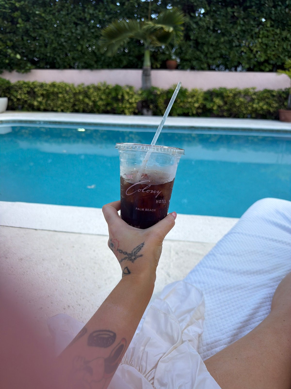 Guest enjoys poolside drink at Palm Beach Colony Hotel