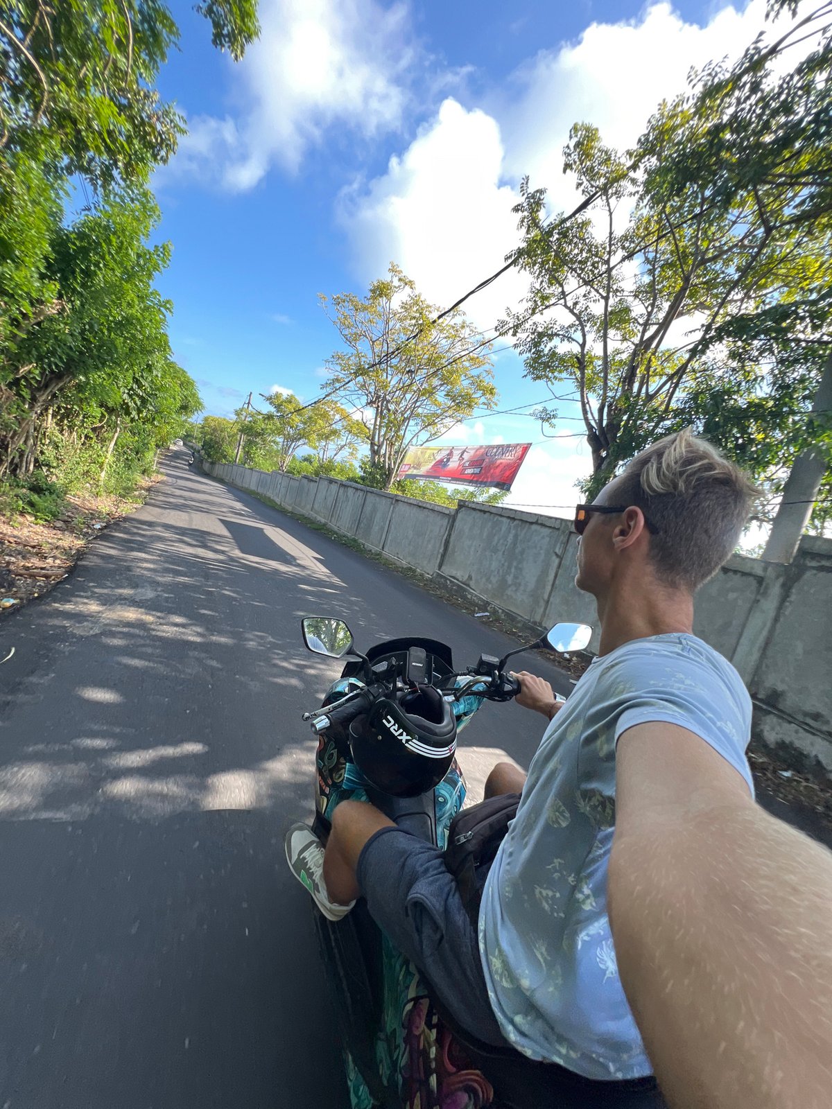 Man rides scooter through Ungasan, Indonesia streets