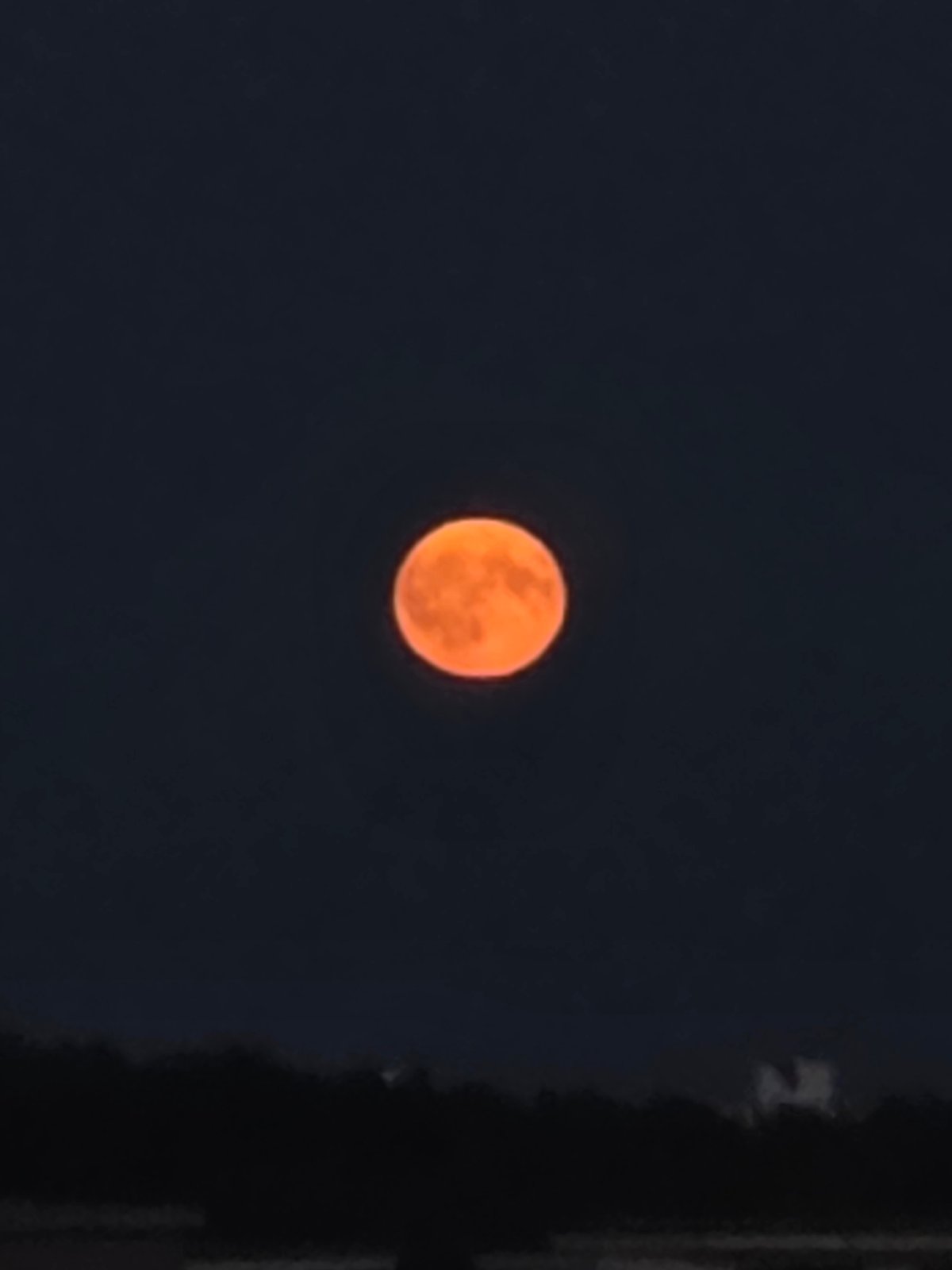 Big orange moon rises over Minsk on a July night