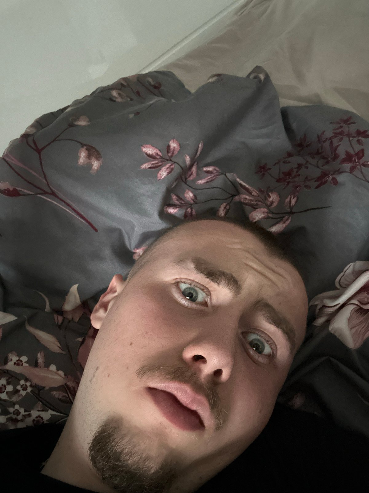 Man takes selfie on floral bedding in Sofia