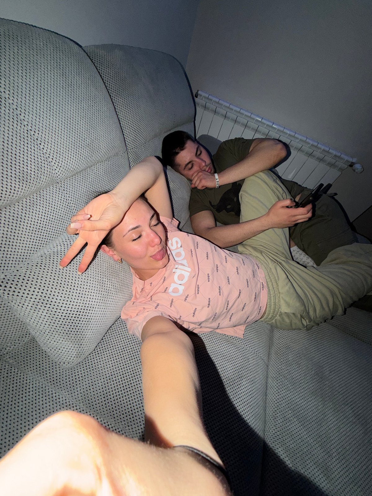 Two people relax on couch, play mobile games in Bulgaria