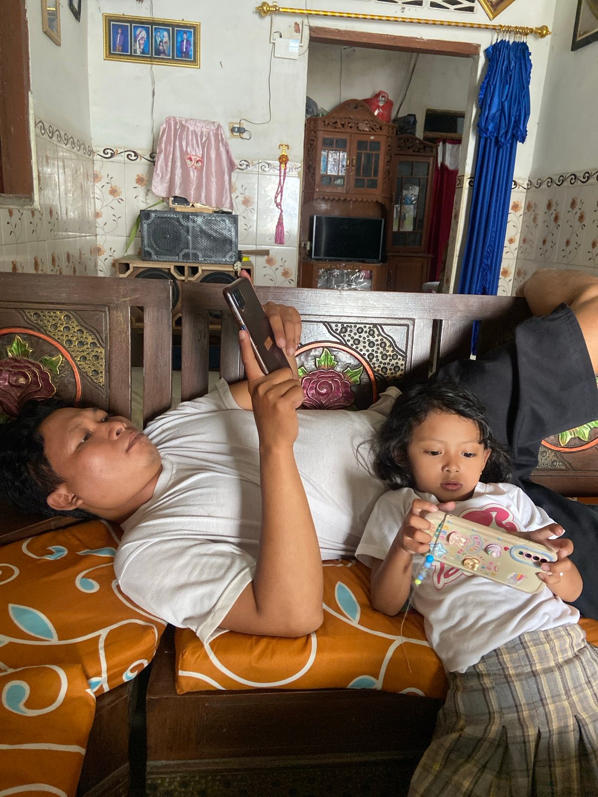 Relaxing at home on a patterned sofa in Baron, Indonesia