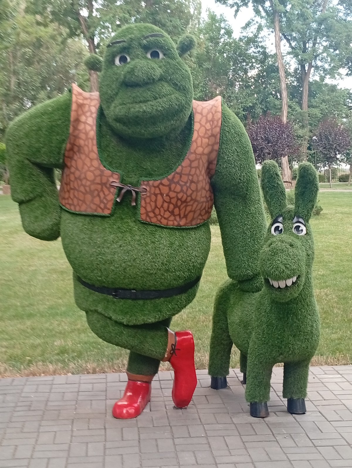 Pokrov city park with cartoon topiaries, fountains, and rides