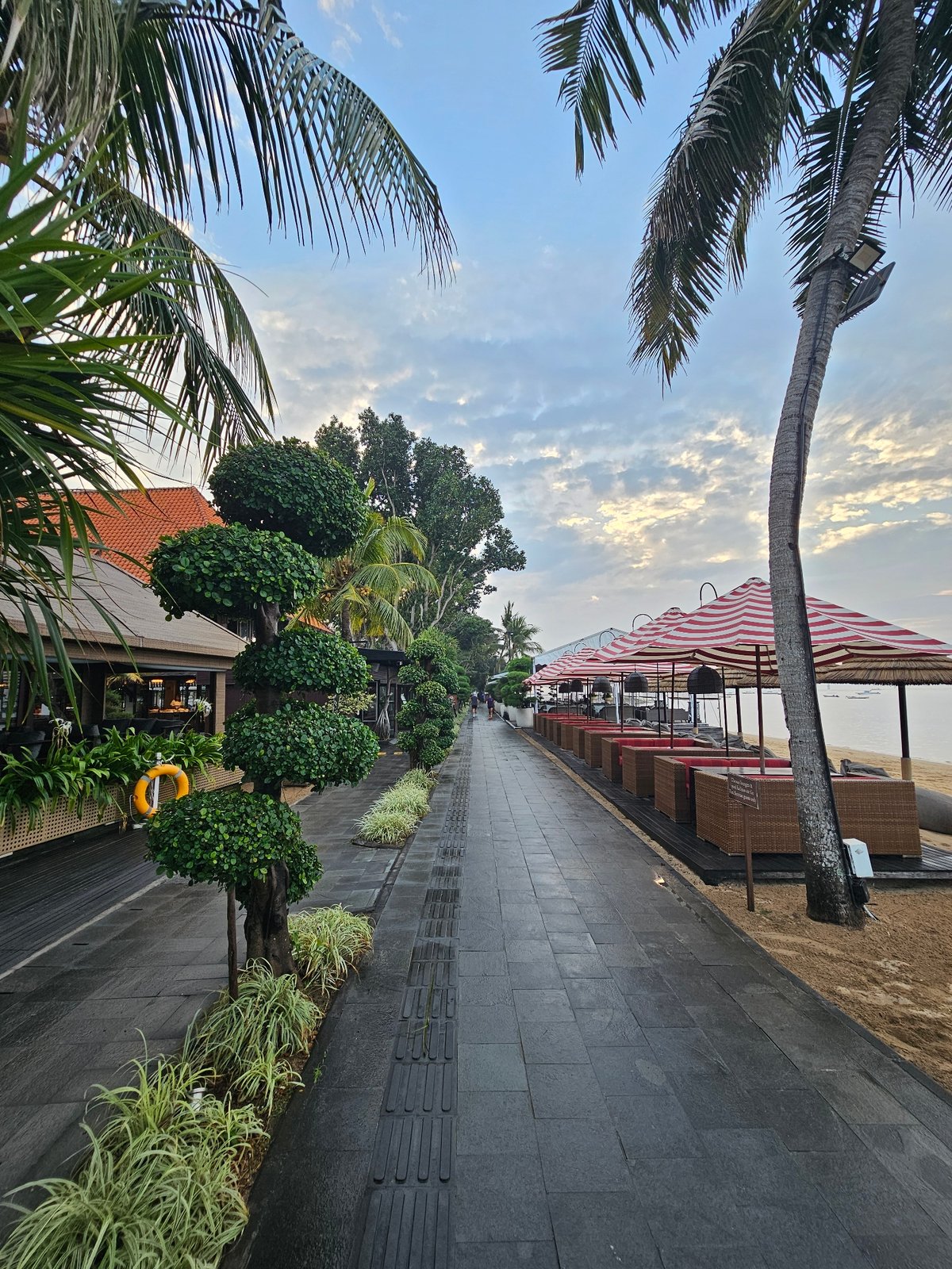 Sanur Beach at dusk: boats, dogs, and a quiet promenade