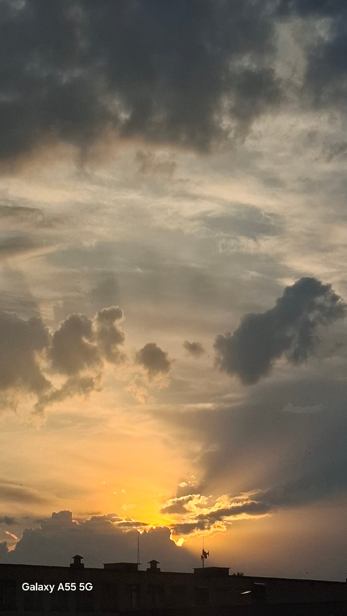 Golden sunset breaks through storm clouds over Tolyatti rooftops