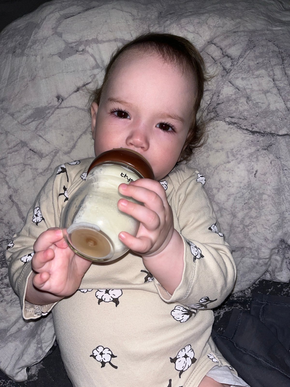 Baby feeds from bottle on patterned blanket in Shushary