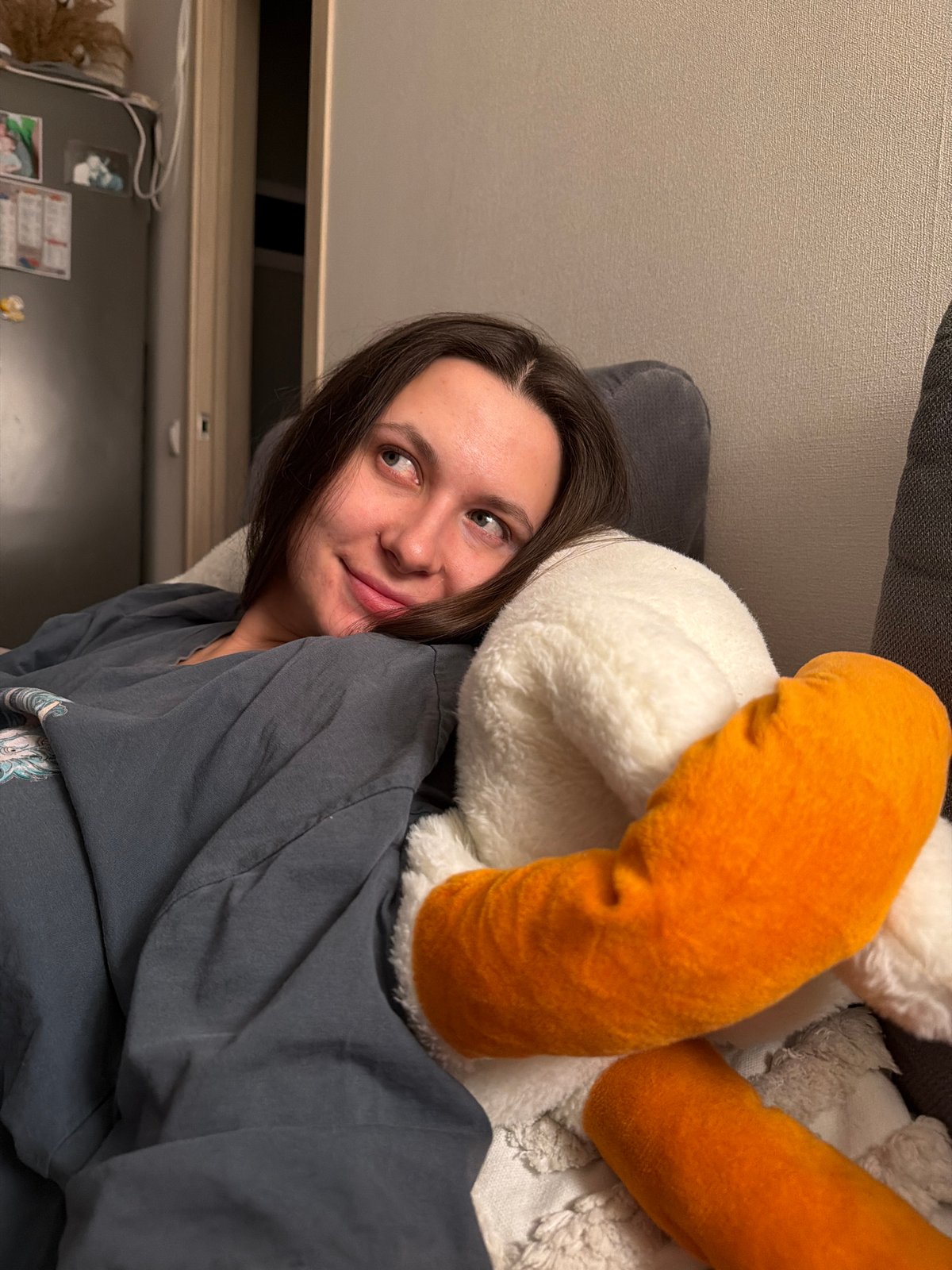 Woman rests with plush toy on sofa in Odintsovo