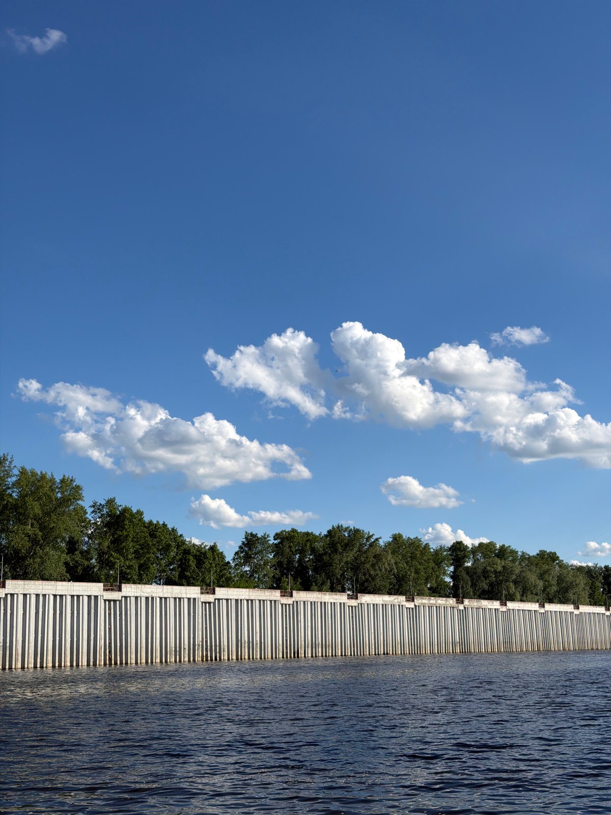 Men fishing at concrete waterway wall in Chaikovsky, Russia