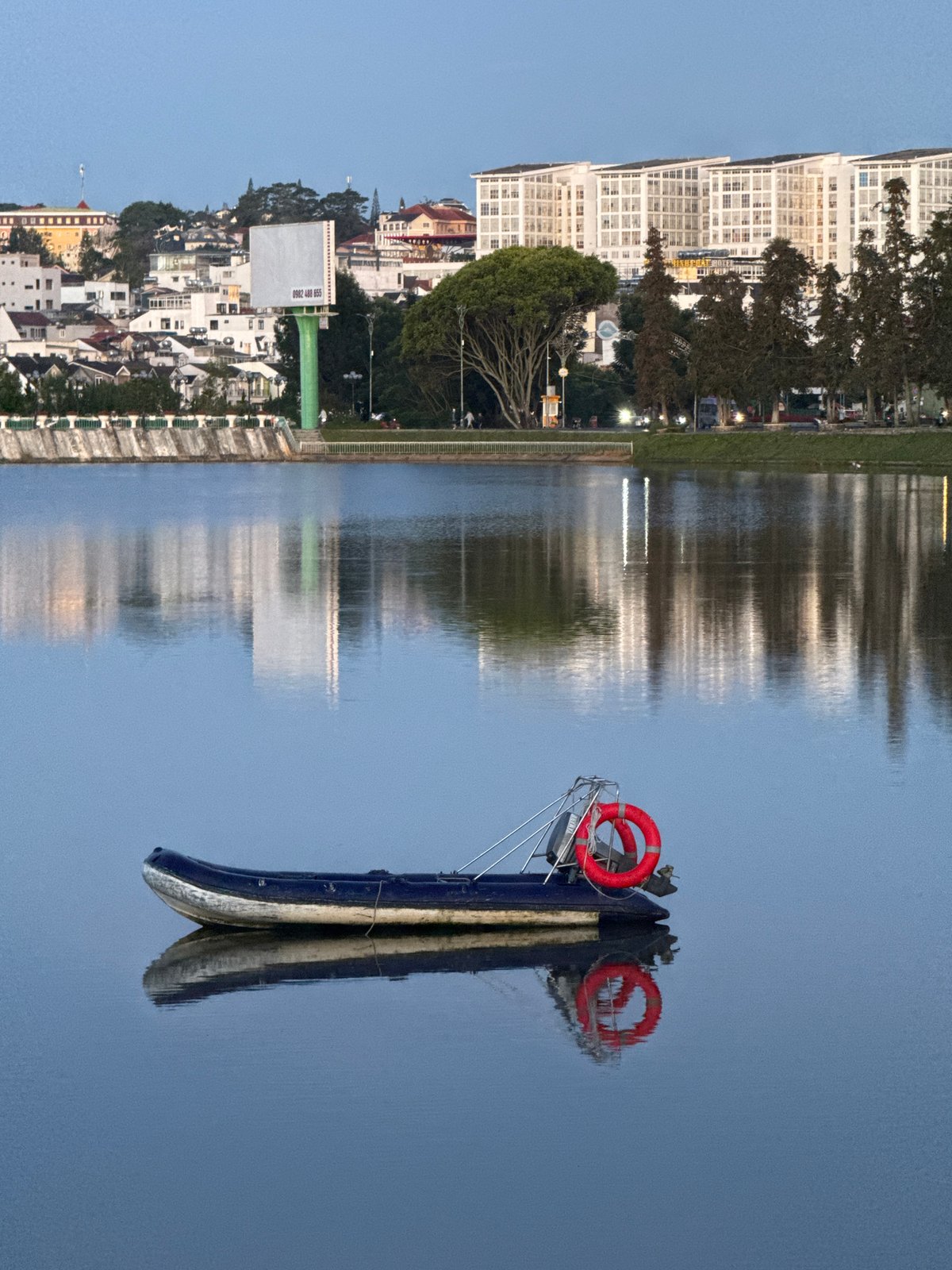 Inflatable boat moored on glassy Xuan Huong Lake, Da Lat