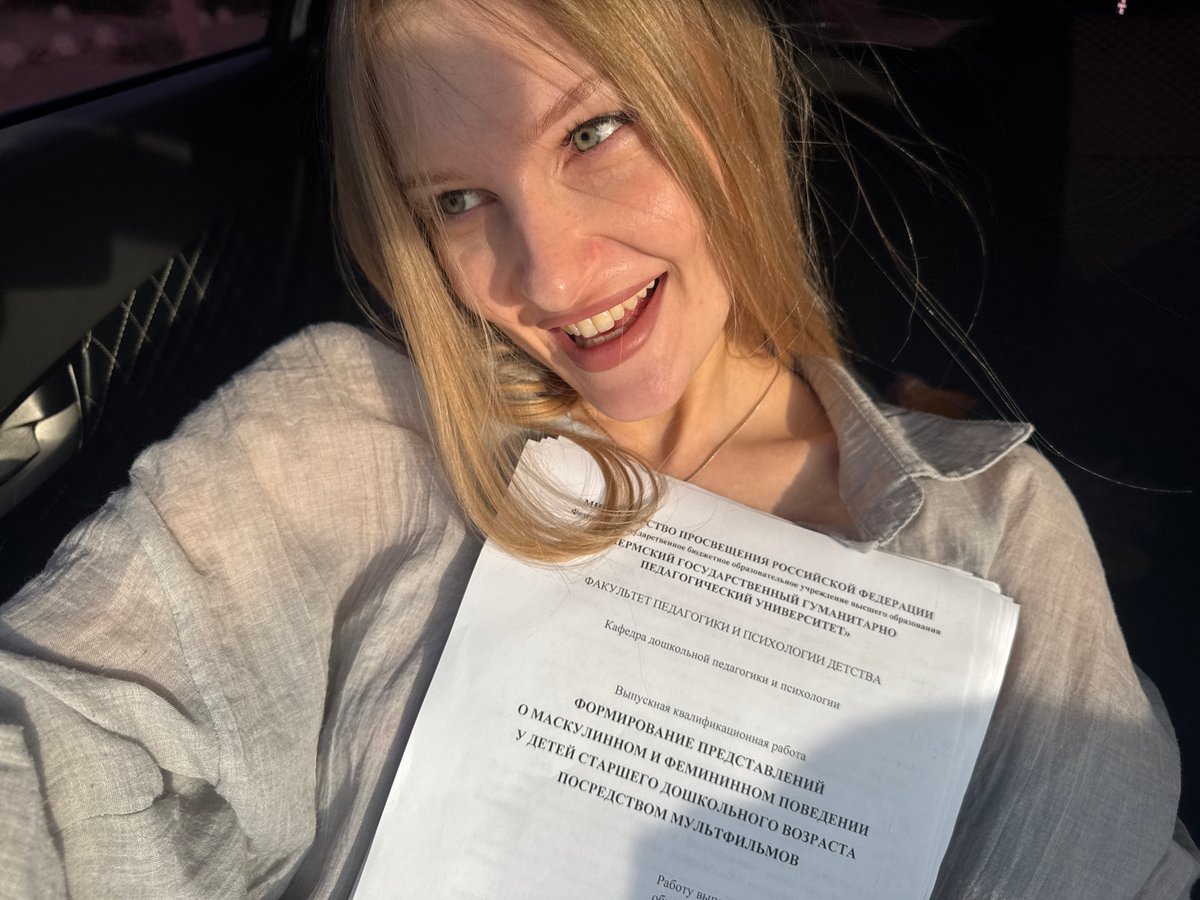 Smiling with a stack of printed documents in Perm