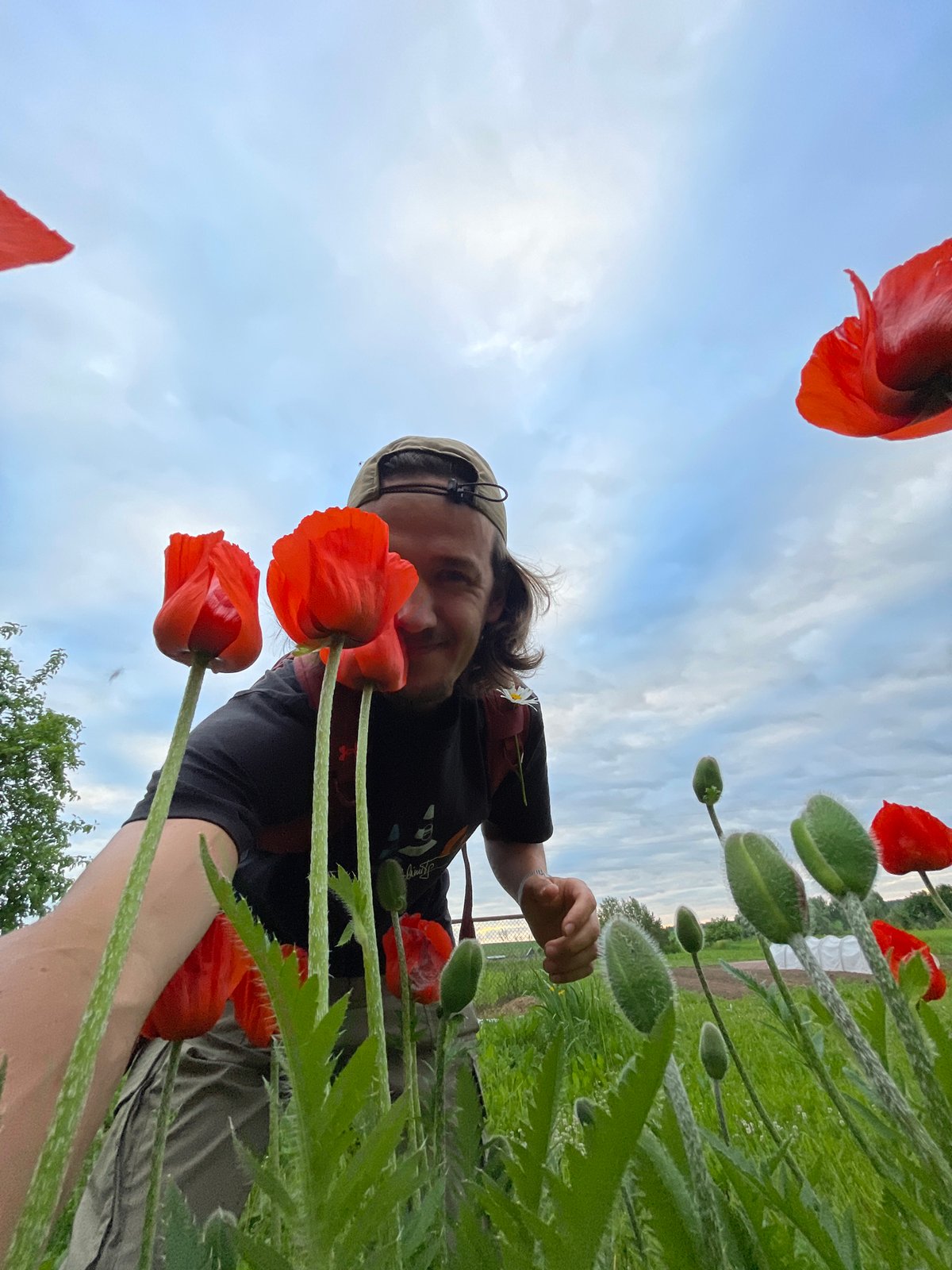 Person explores flower fields, takes selfies amid blooming gardens