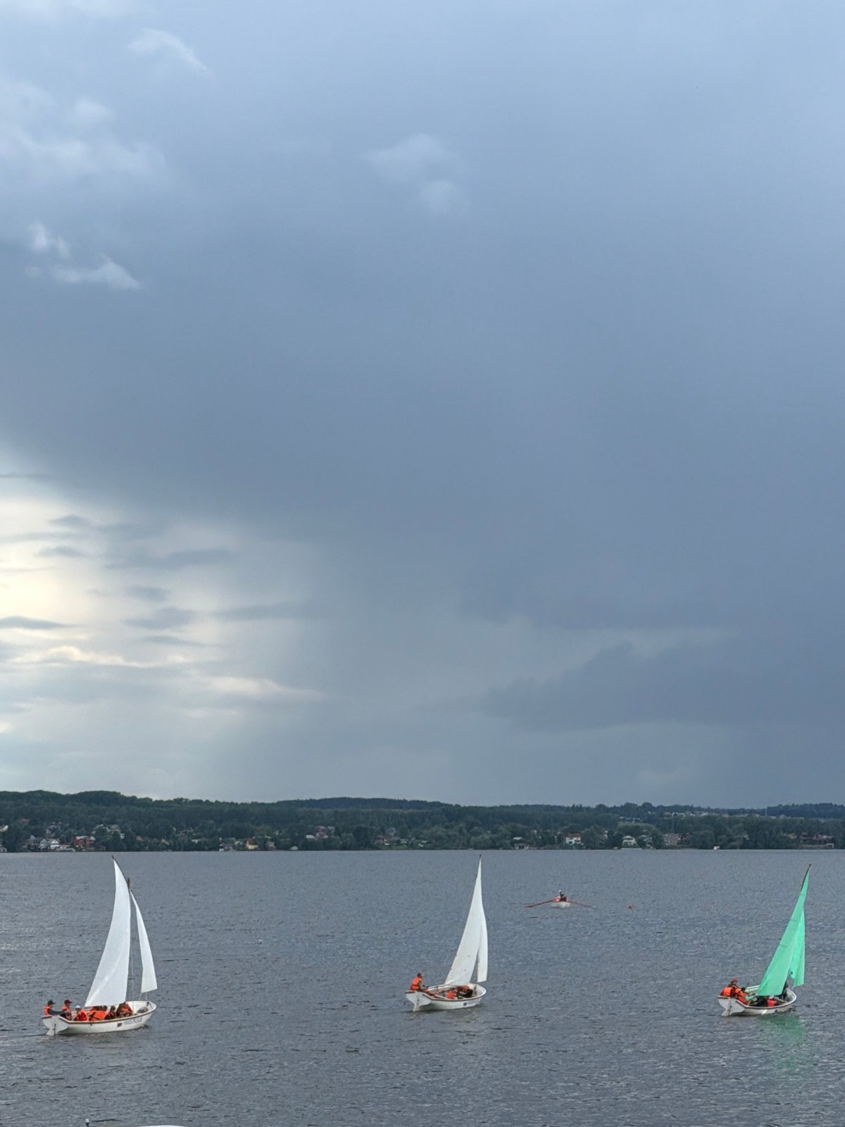 Sailboats navigate calm waters under cloudy skies in Votkinsk