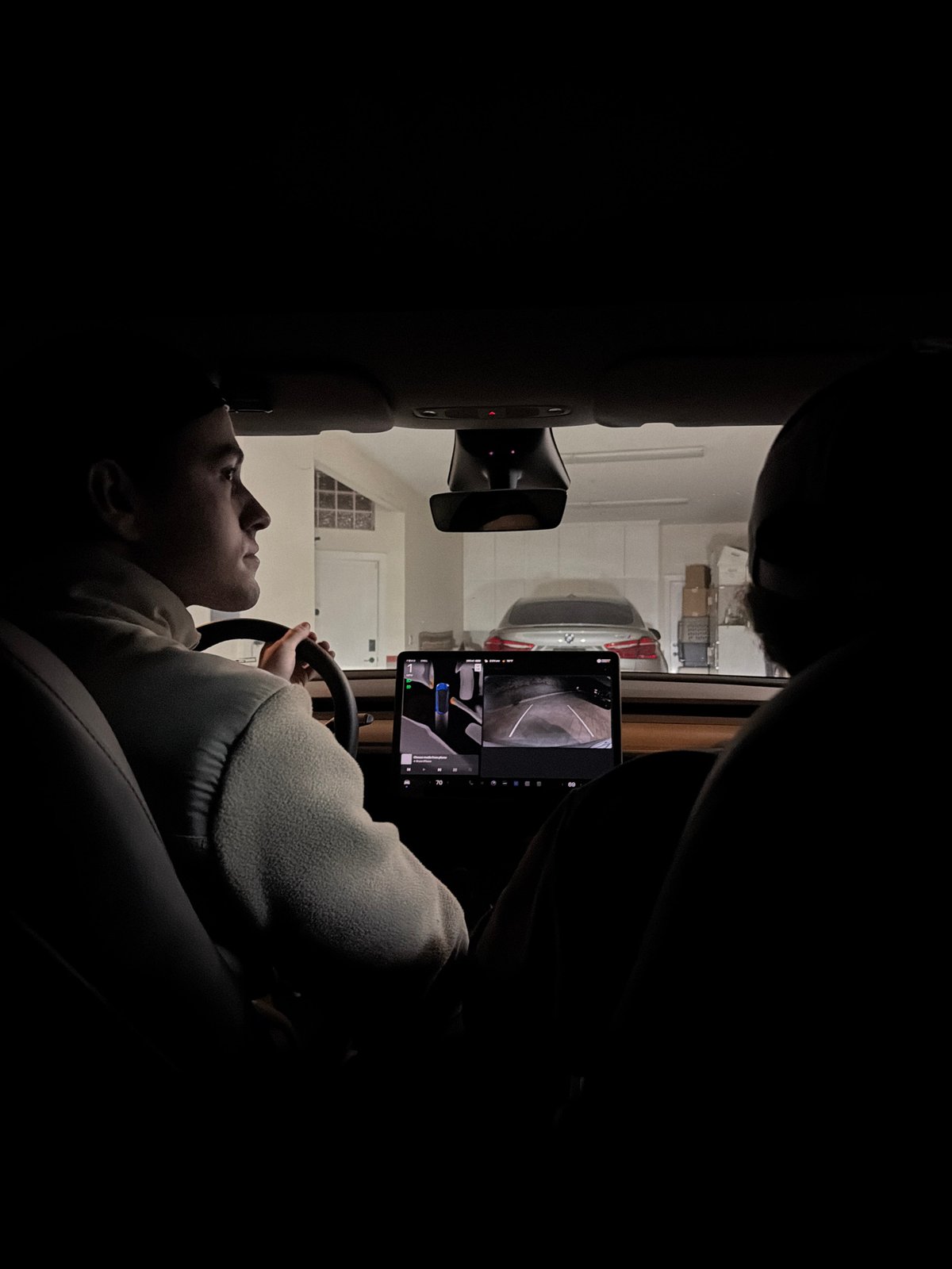 Driver checks dashboard tablet in Tesla garage Santa Ana