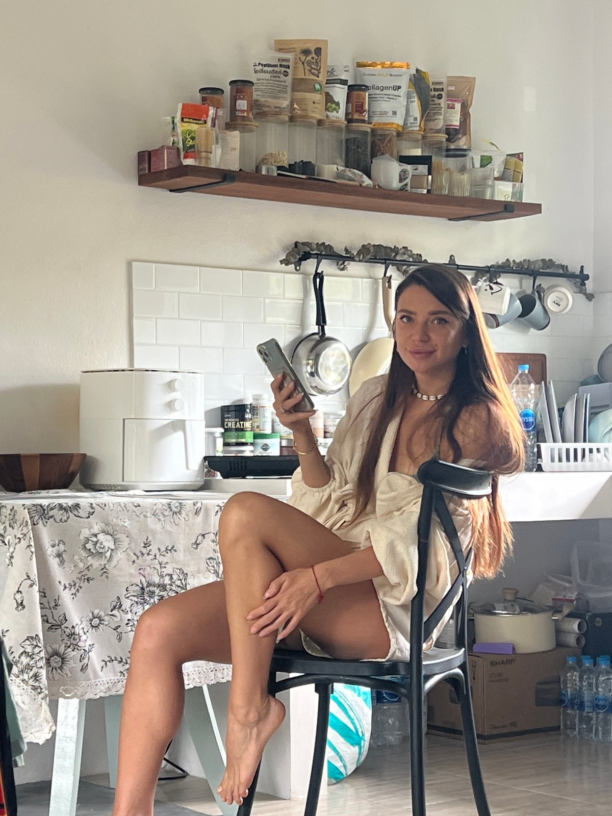 Woman uses phone in kitchen, บ้านบางรักษ์, Thailand