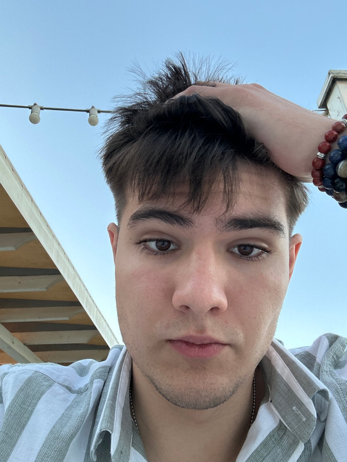 Low-angle selfie in Odesa featuring a colorful beaded bracelet