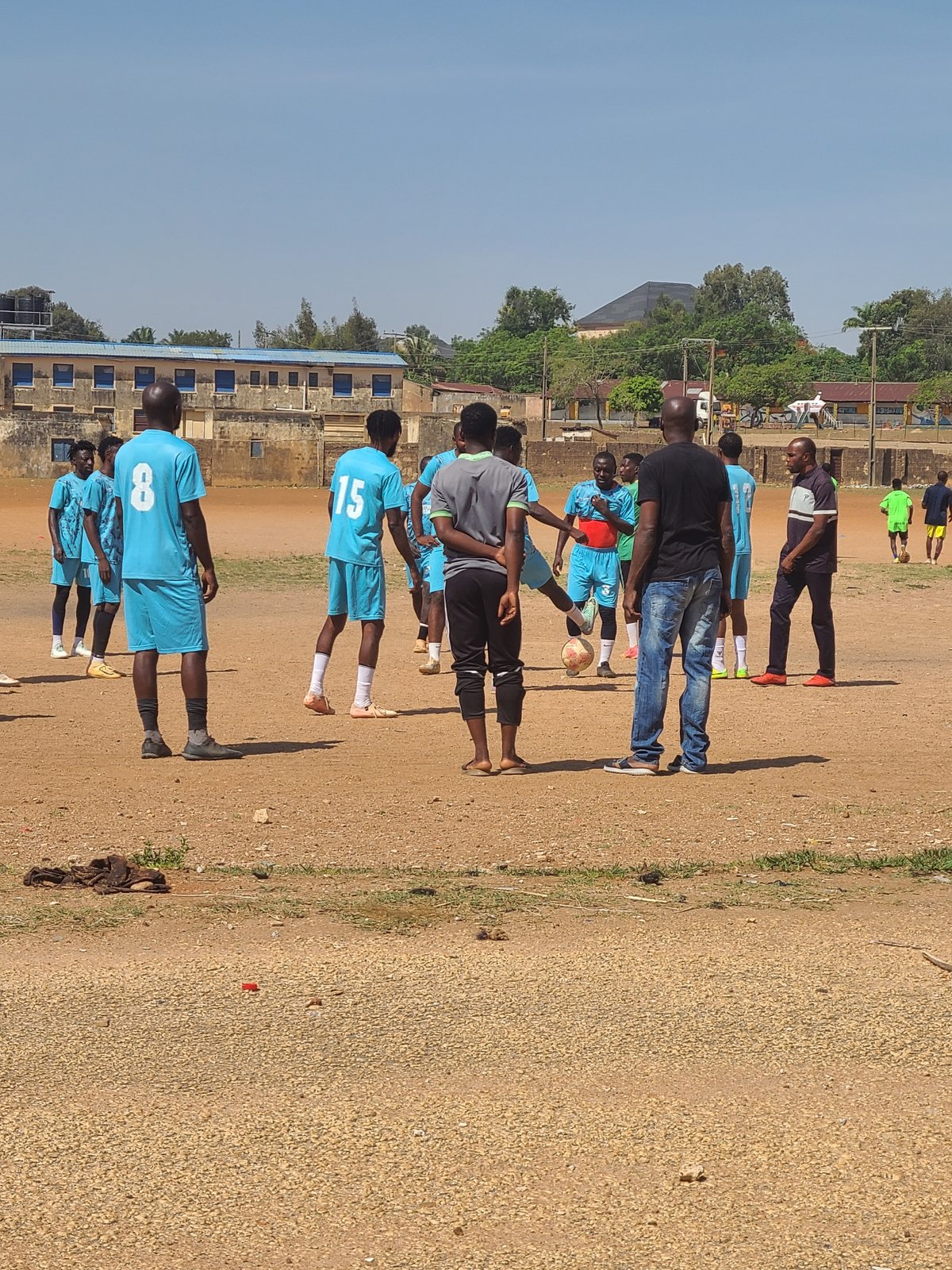 Soccer team holds training session on dirt field