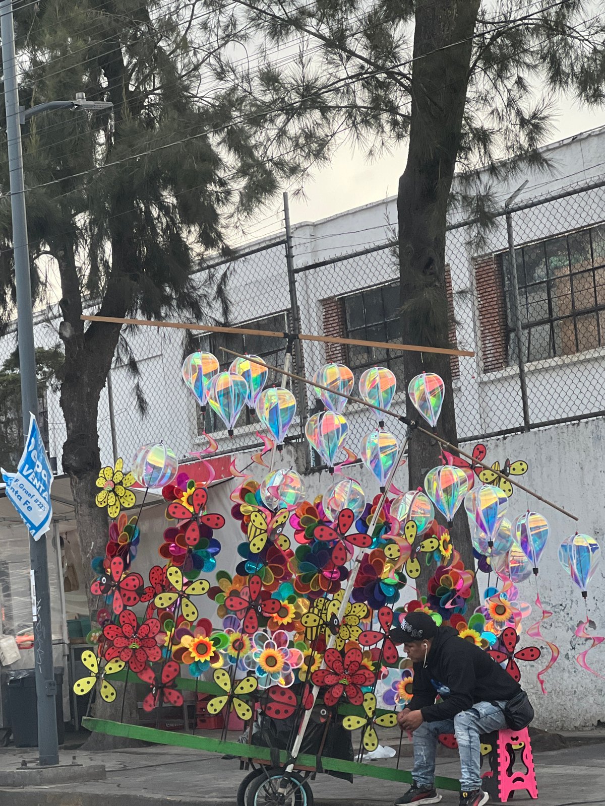 Street vendor sells colorful pinwheels from cart in Mexico City