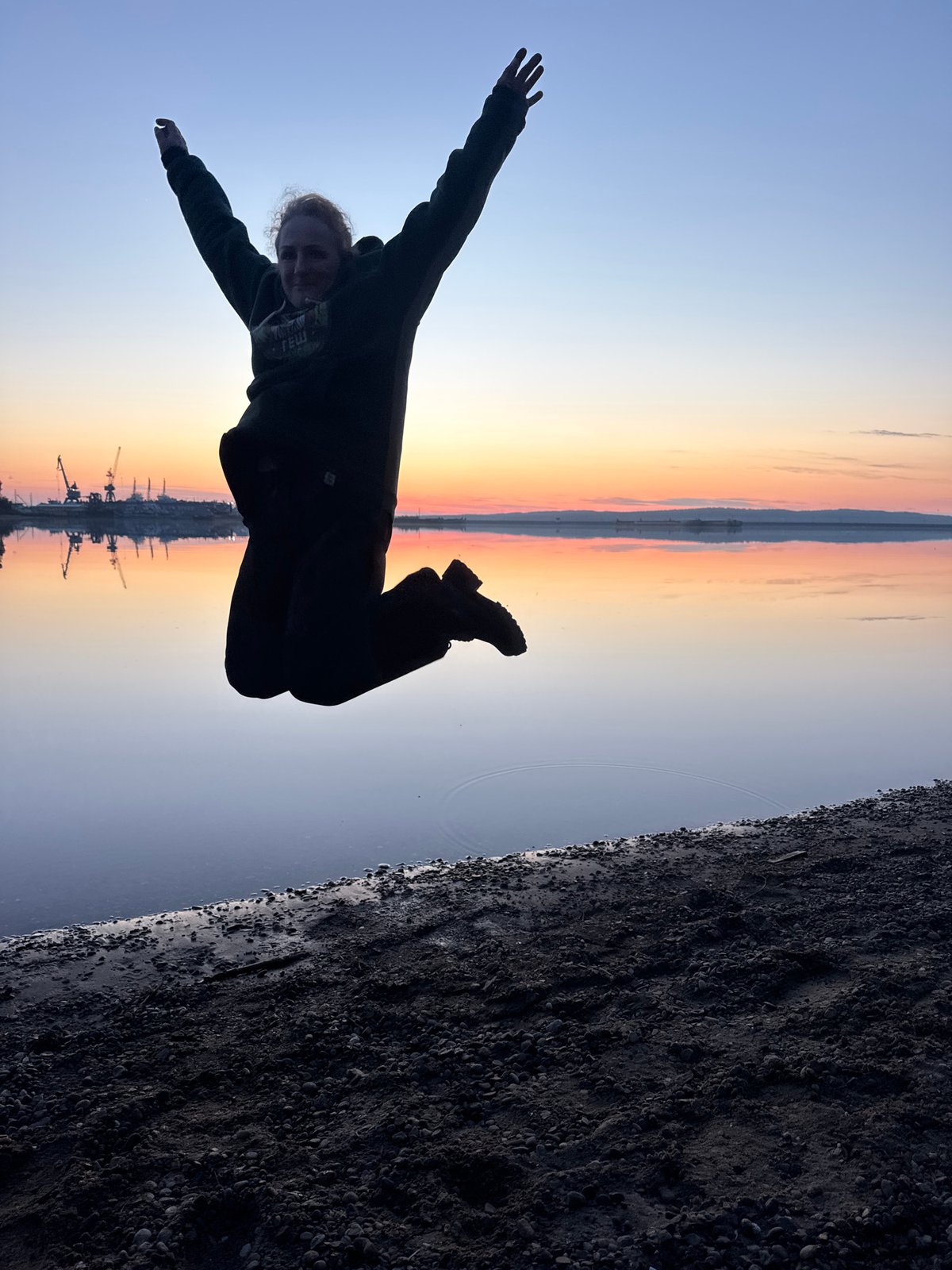 Person photographed in dynamic pose against twilight sky in Russia