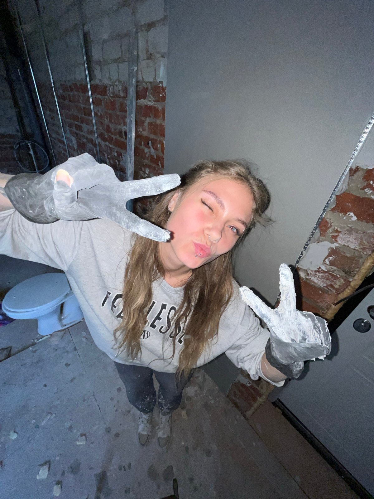 Woman makes peace signs during construction work break