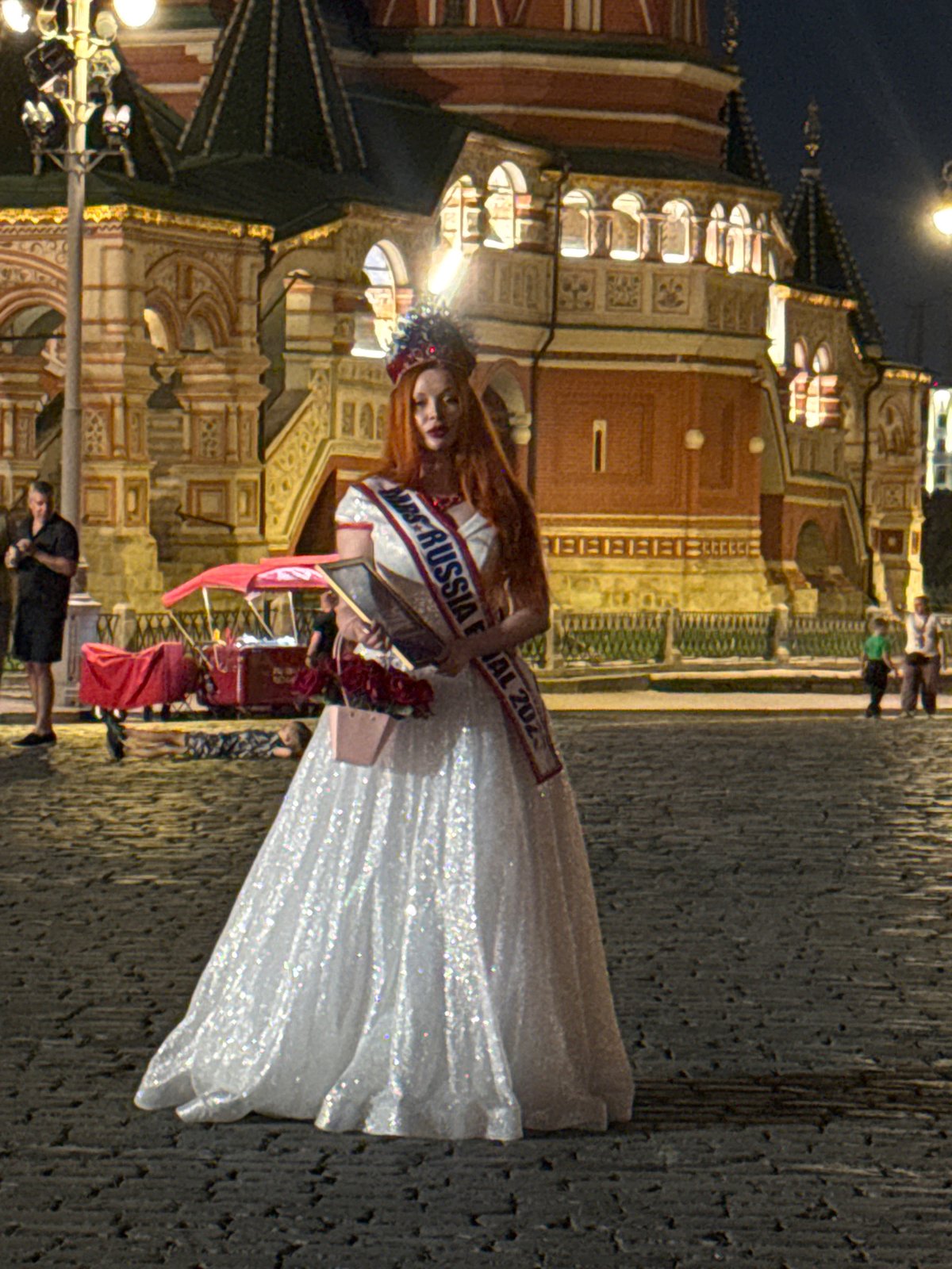 Pageant title holders pose at Red Square on a summer night