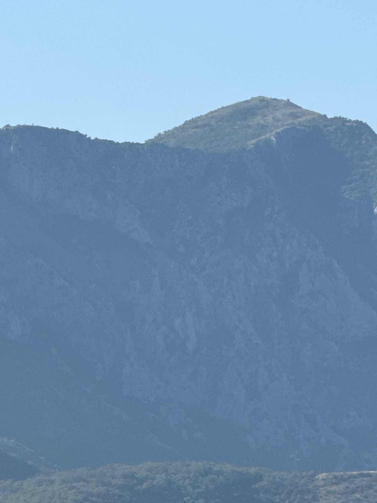 White superyacht anchored off the rocky Montenegrin coastline at Boreti