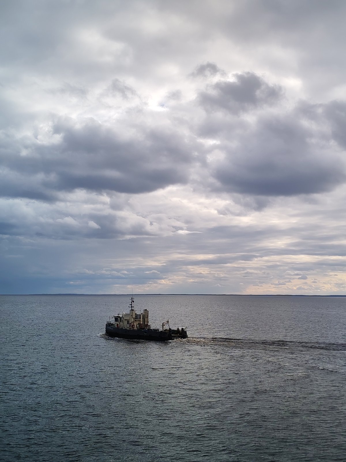 Lone boat spotted under dramatic overcast skies in Russia