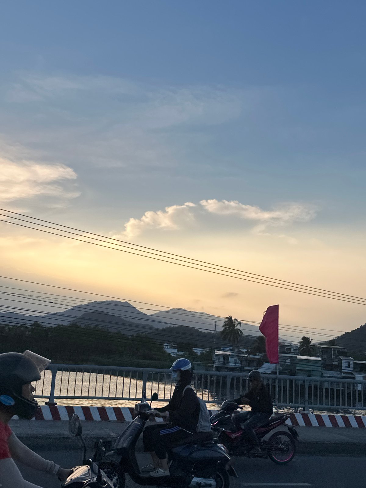 Motorbikes gather on bridge during sunset in Nha Trang