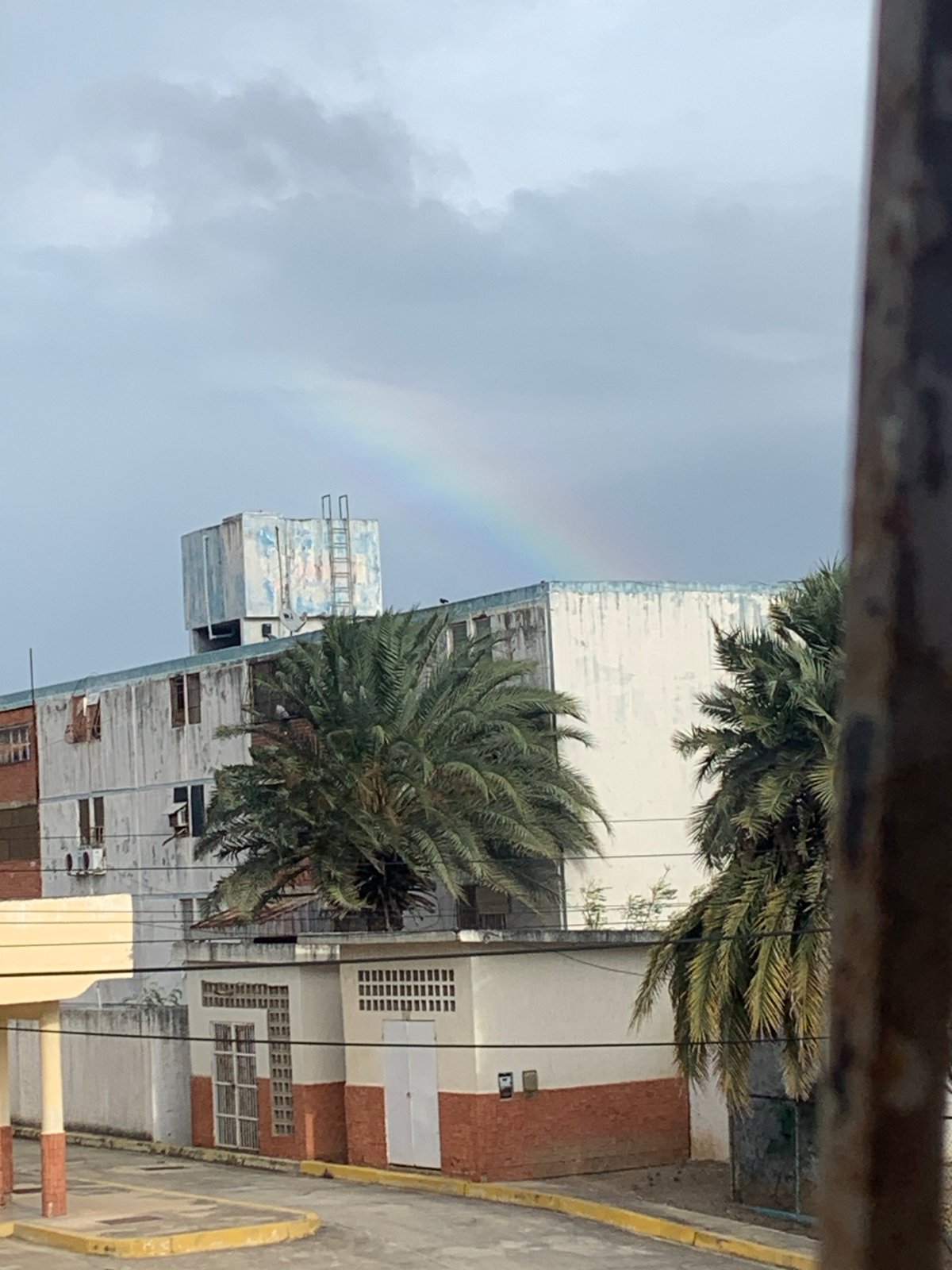 Rainbow spotted over urban buildings after possible rainfall