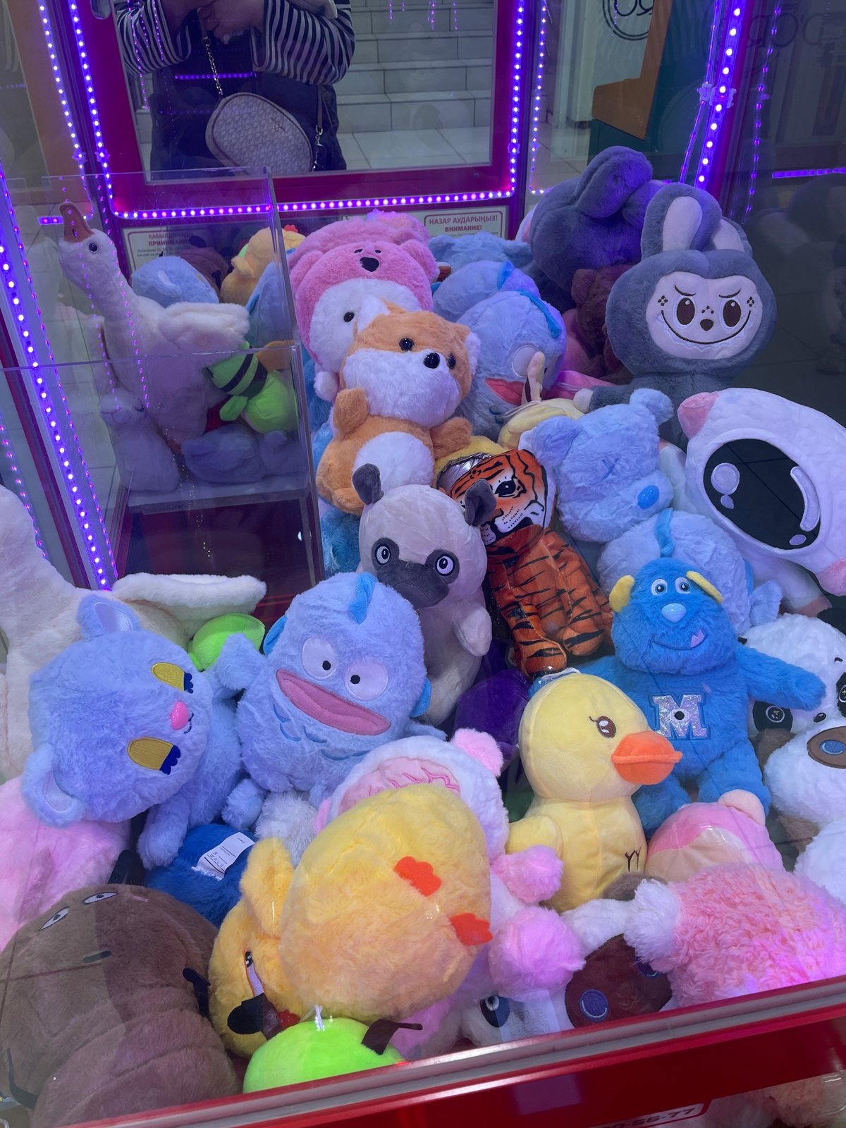 Child shops with toy cart near claw machine in Kazakhstan
