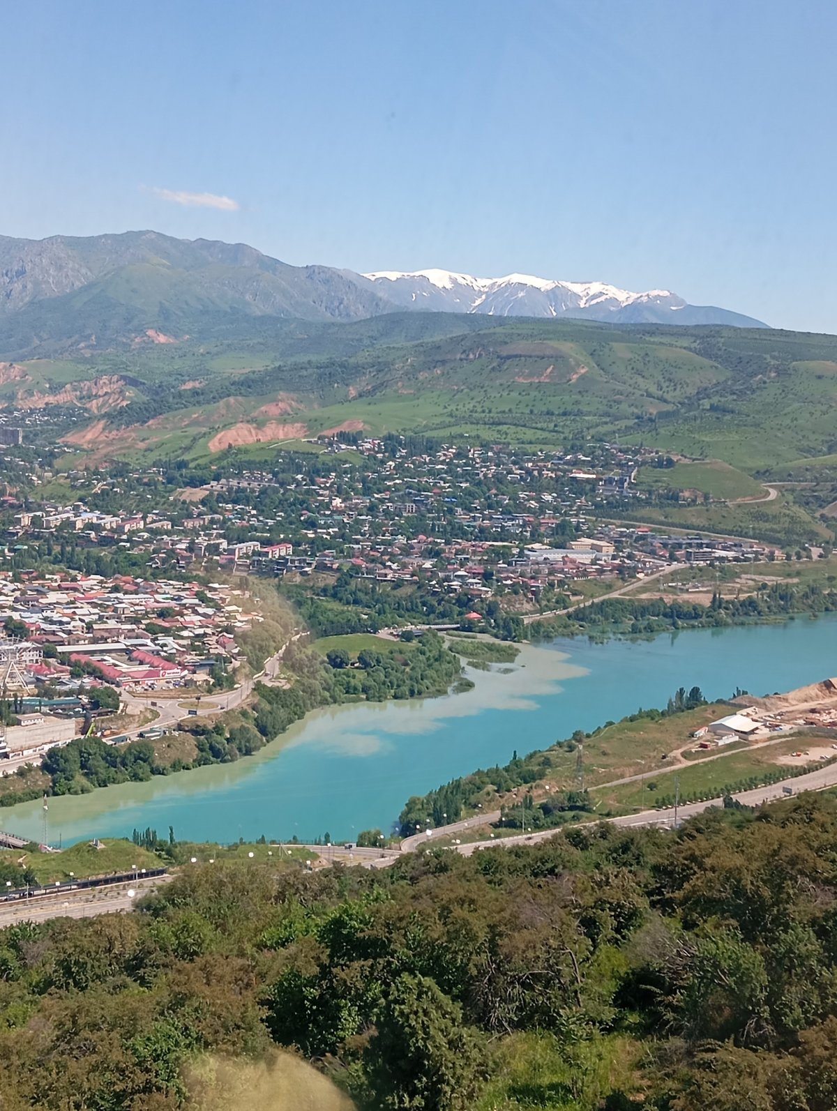 Aerial view captures Chinarkent valley with turquoise river, highway