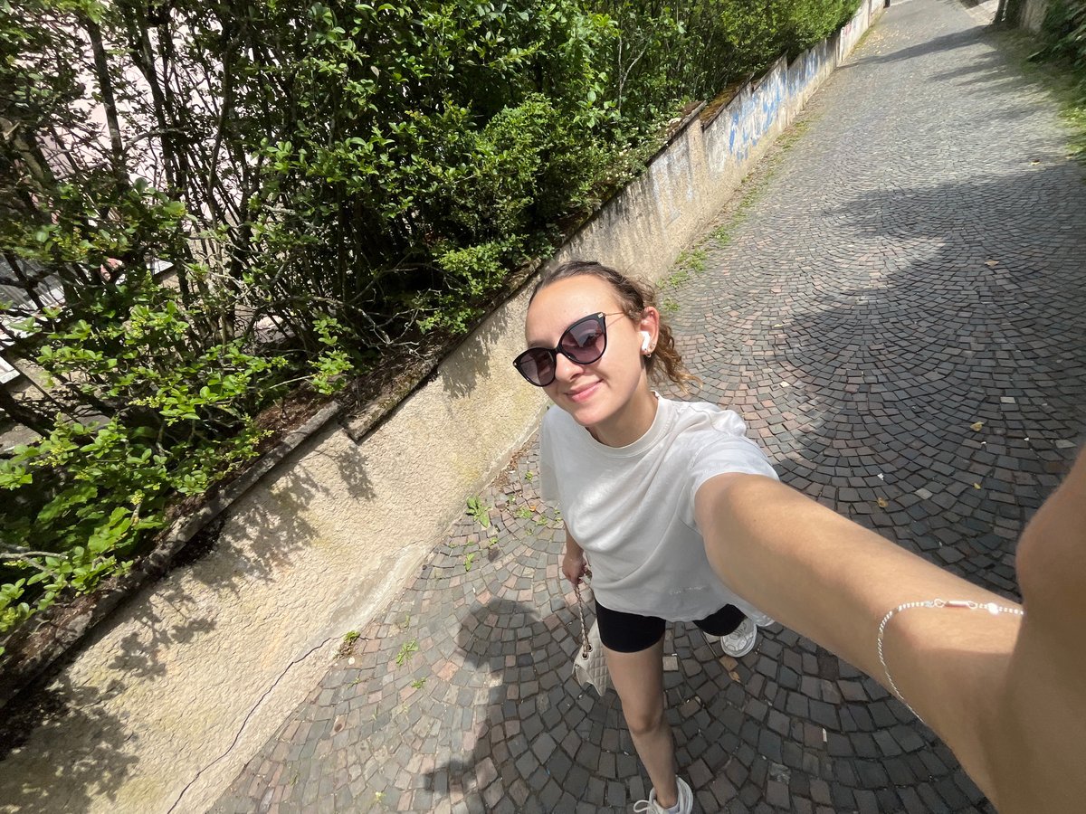 Woman takes selfies on cobblestone street in Saarbrücken